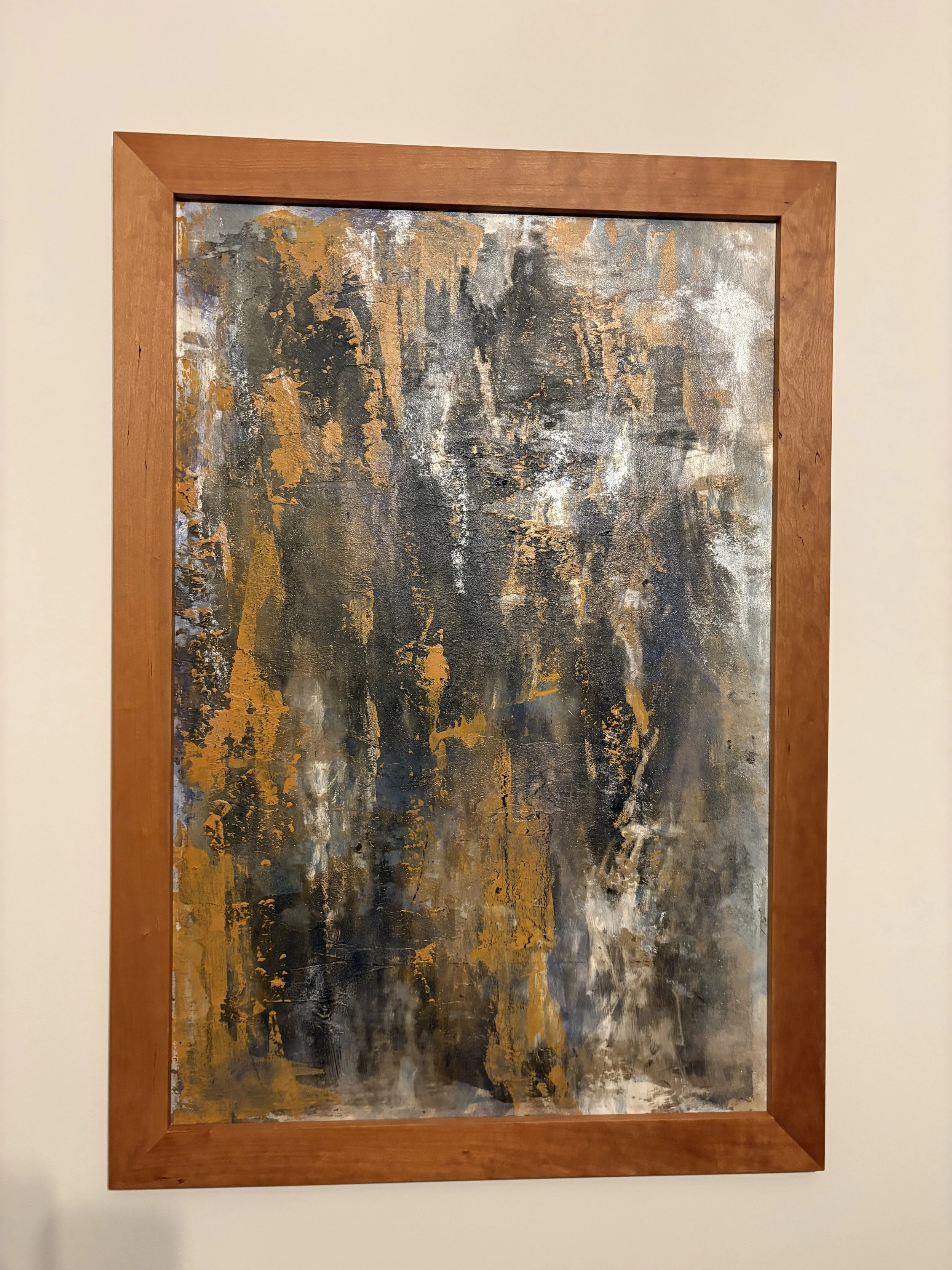 abstract painting in cherry wood frame on white wall