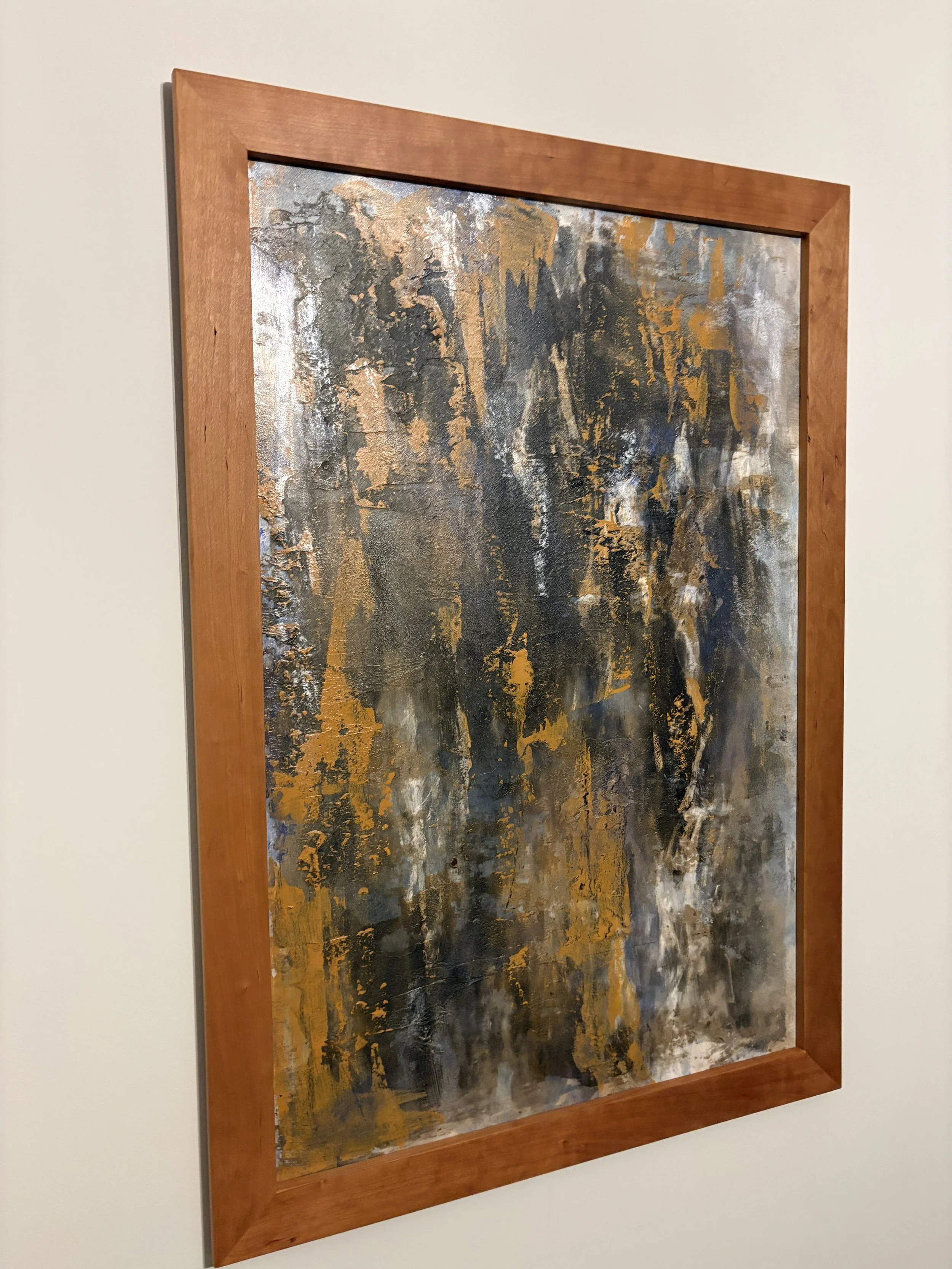 abstract painting in cherry wood frame on white wall