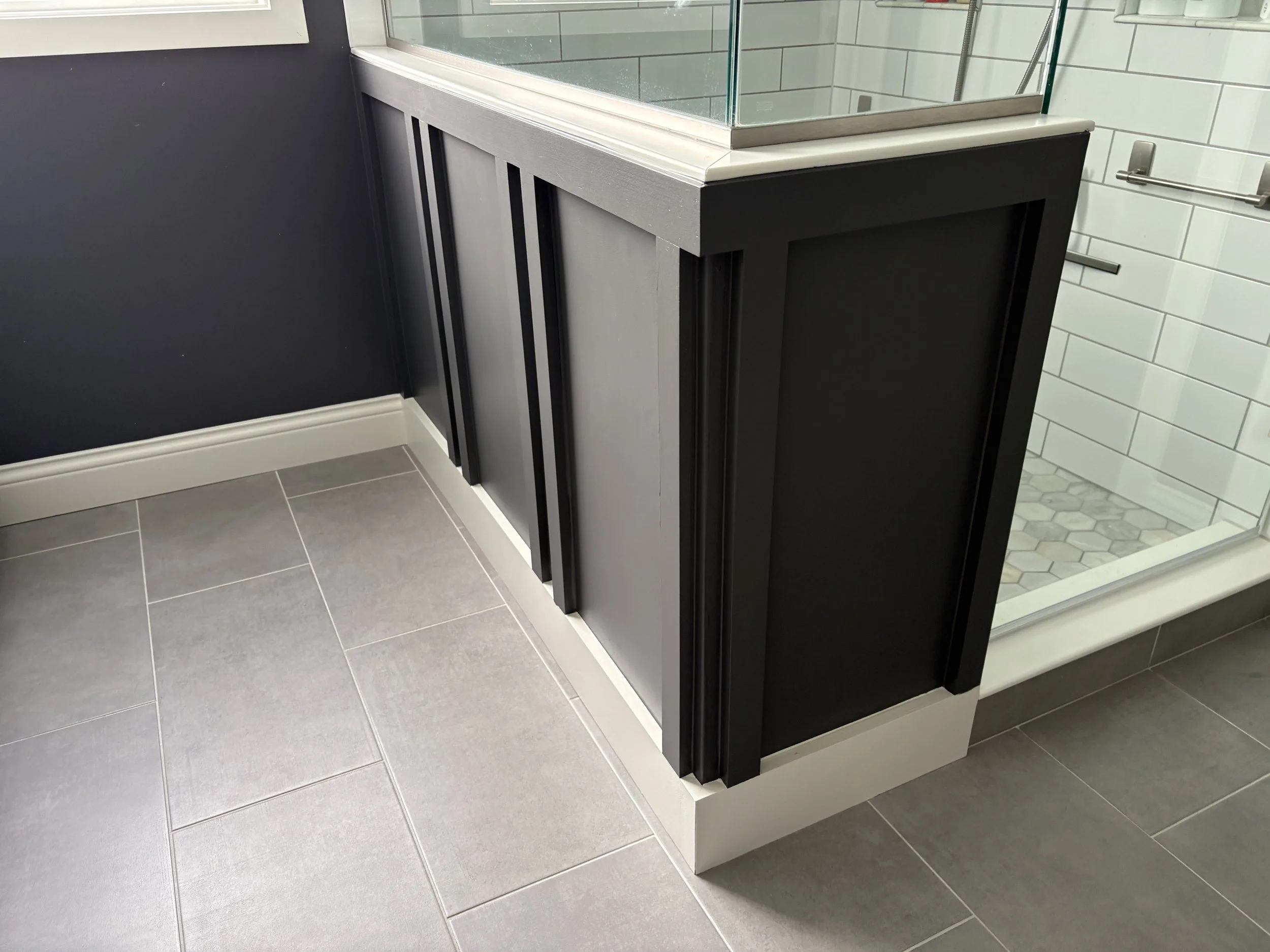 gray board and batten in bathroom with white trim, shower and gray tile