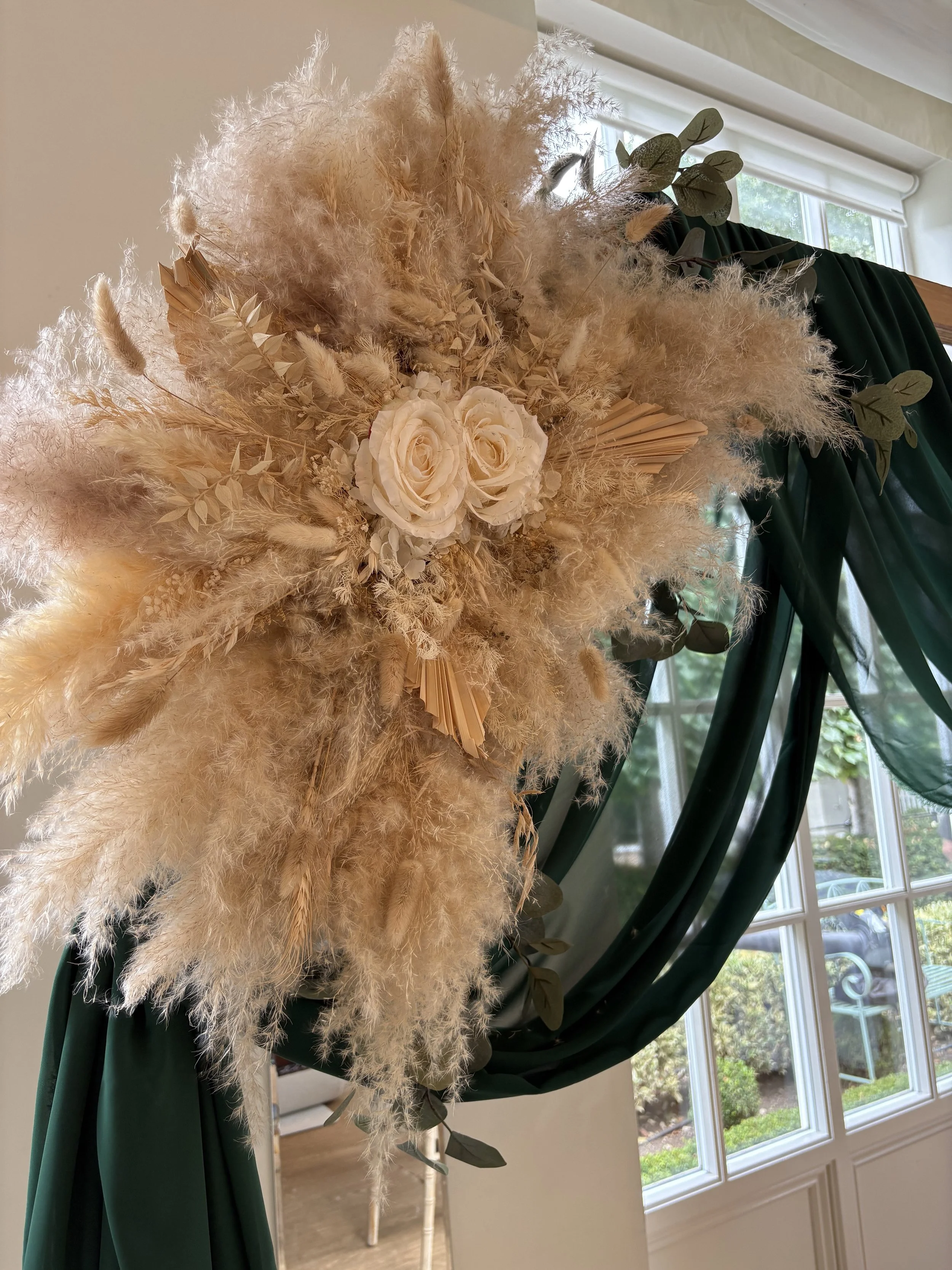 Dream Decor_Warwick House_large Pampas and foliage arrangement on hexagonal wooden arch with a dark green chiffon drape