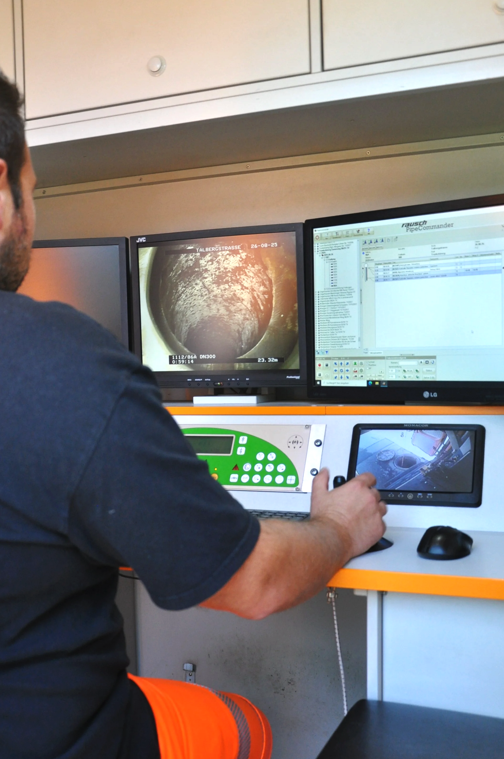 Mitarbeiter überwacht eine Rohrinspektion auf einem Monitor. Der Bildschirm zeigt eine Kameraaufnahme des Rohrinneren, ergänzt durch eine zweite Anzeige mit Software-Details.