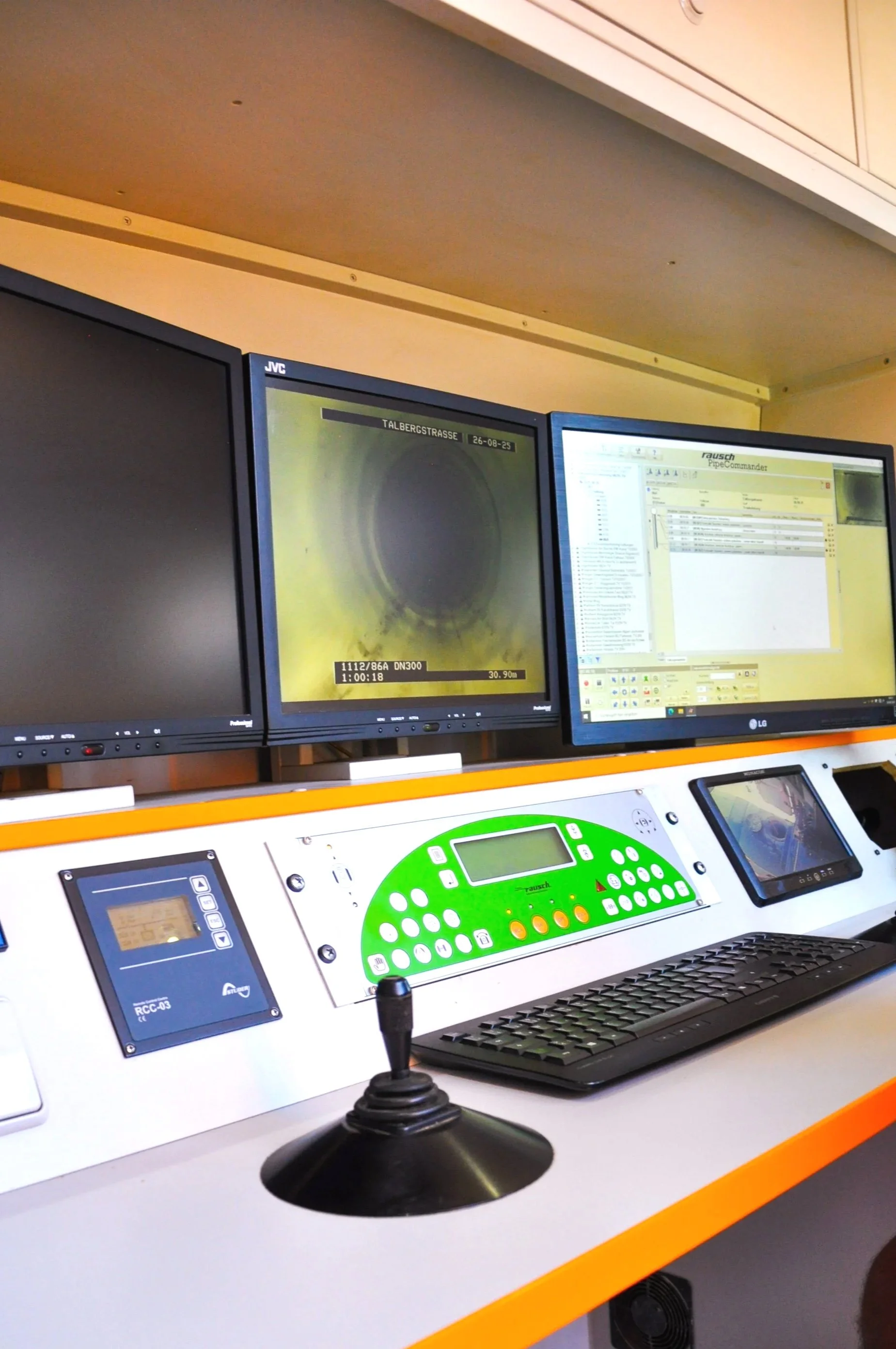 Ein Kontrollraum mit mehreren Monitoren, Tastatur, Joystick und Steuerpult, vermutlich bei einer technischen Überwachung oder Steuerung.