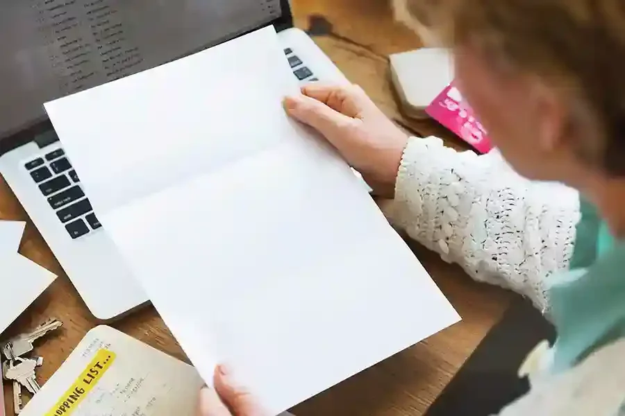 A person reviewing council tax correspondence at a desk with a laptop