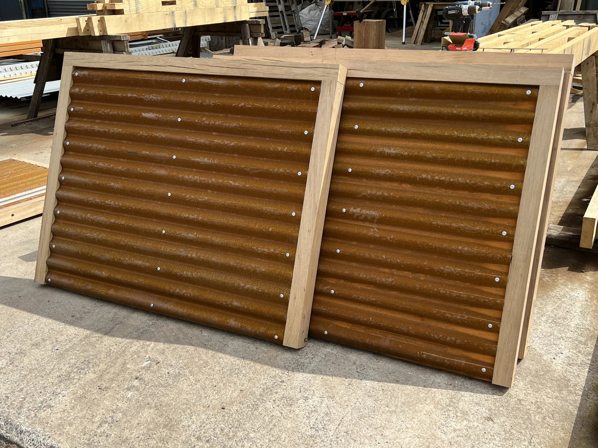 Bespoke Corten screens stacked in workshop after being made. Timber frame surround and stainless fixings