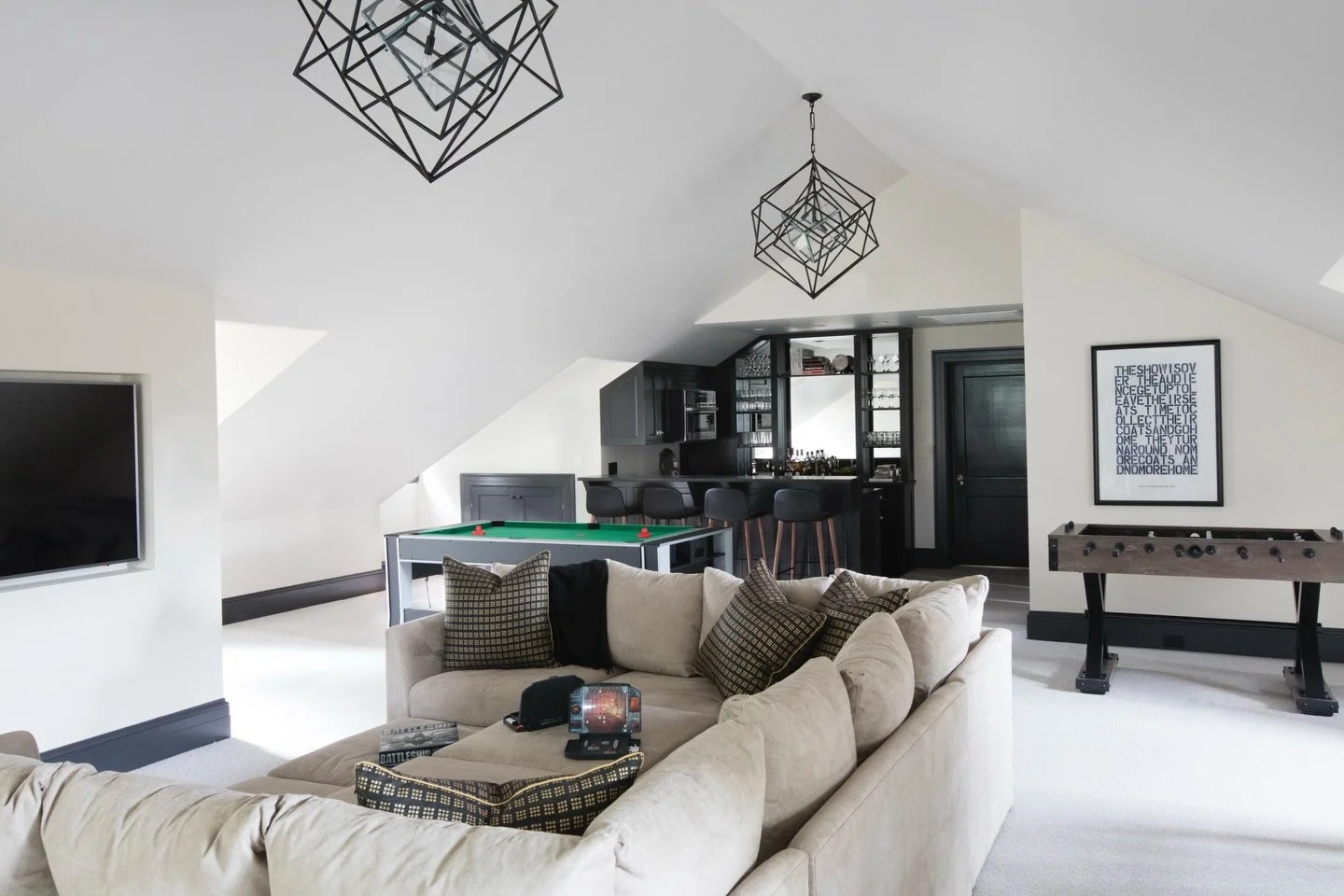 This robust entertainment room on the third floor of our Cottage Farm historic renovation is just one of the few spaces that underwent a dramatic transformation. To preserve the high ceilings and spacious feel, we added modern HVAC in the knee walls 