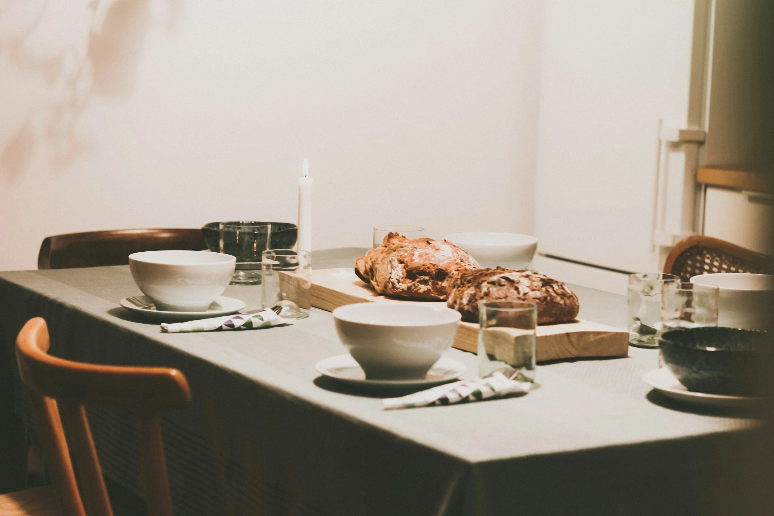 fresh baked bread in the center of a dinner table setting