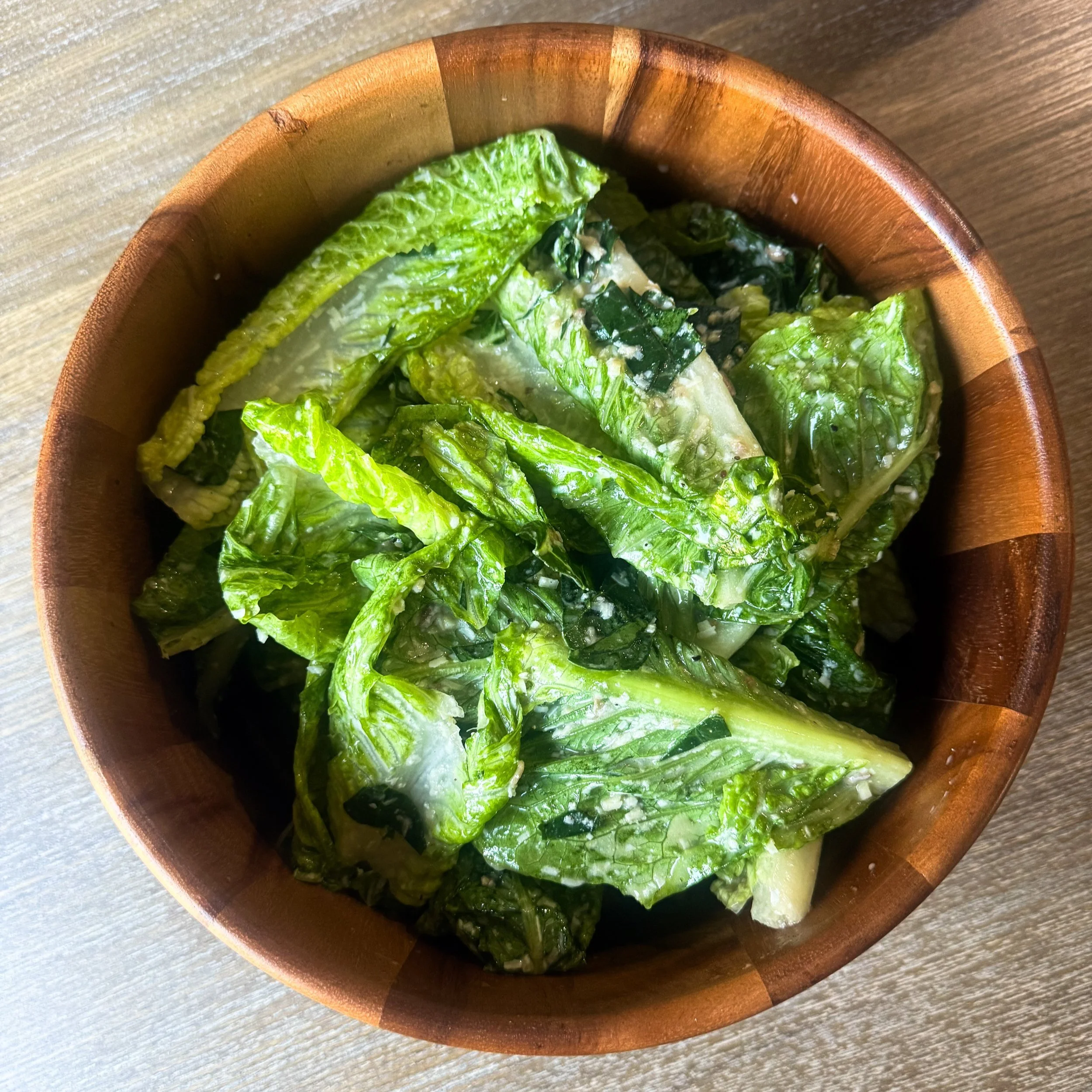 Collard Green Caesar Salad with Cornbread Croutons in a large bowl