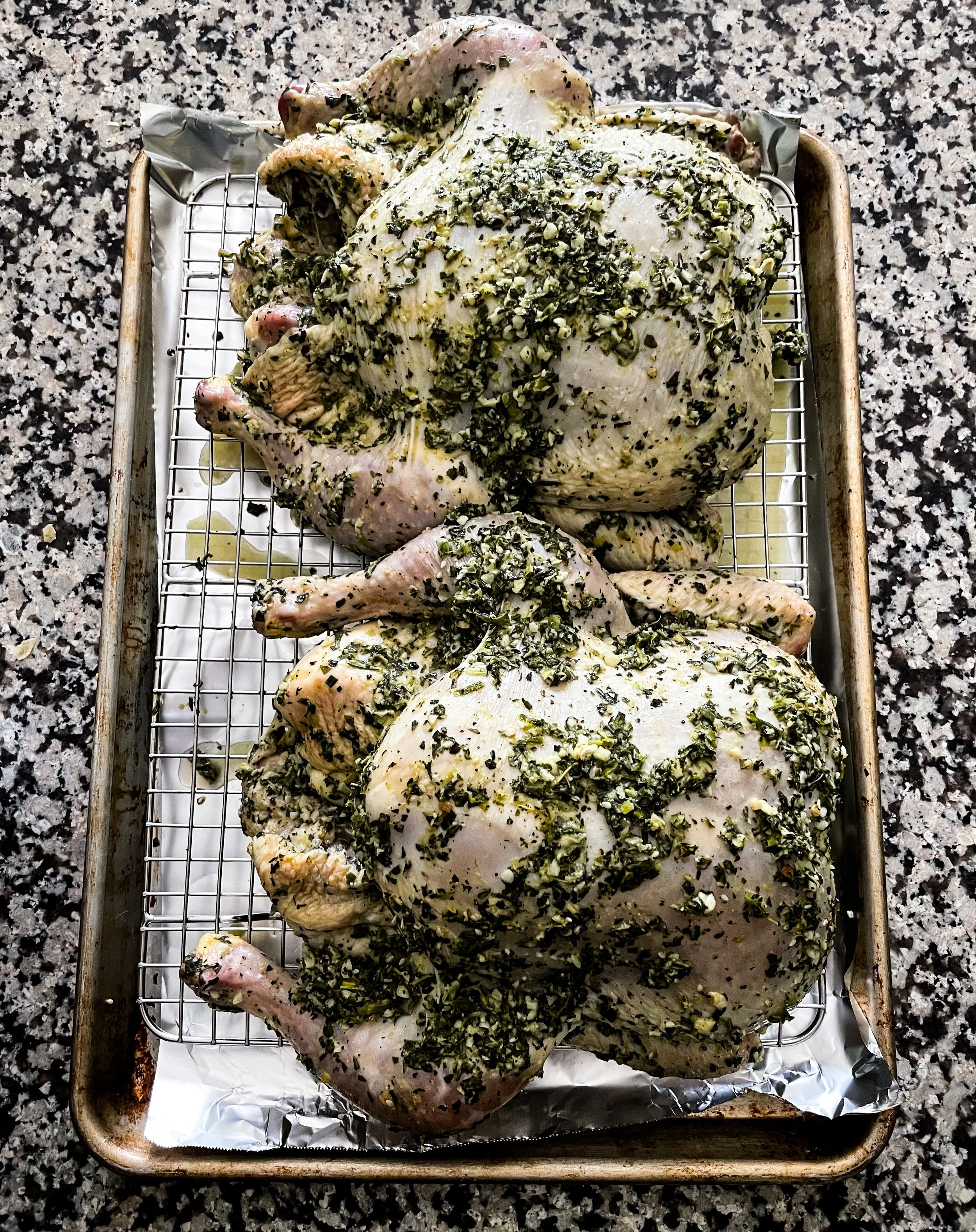 Stuffed chickens prepped on a sheet pan