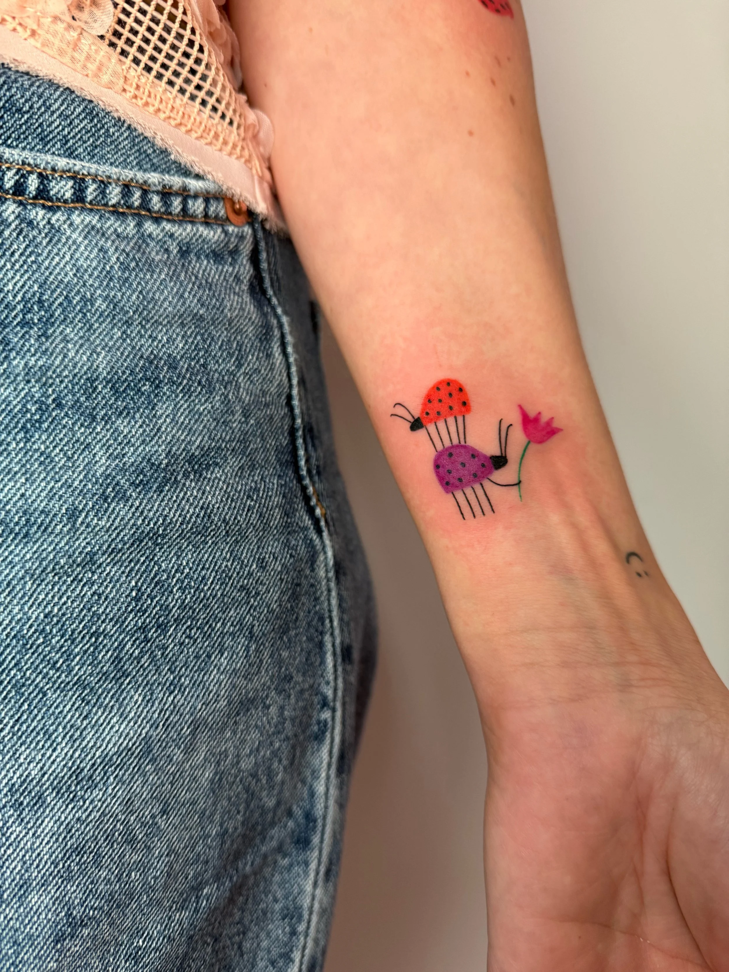 a custom tattoo of colorful ladybugs