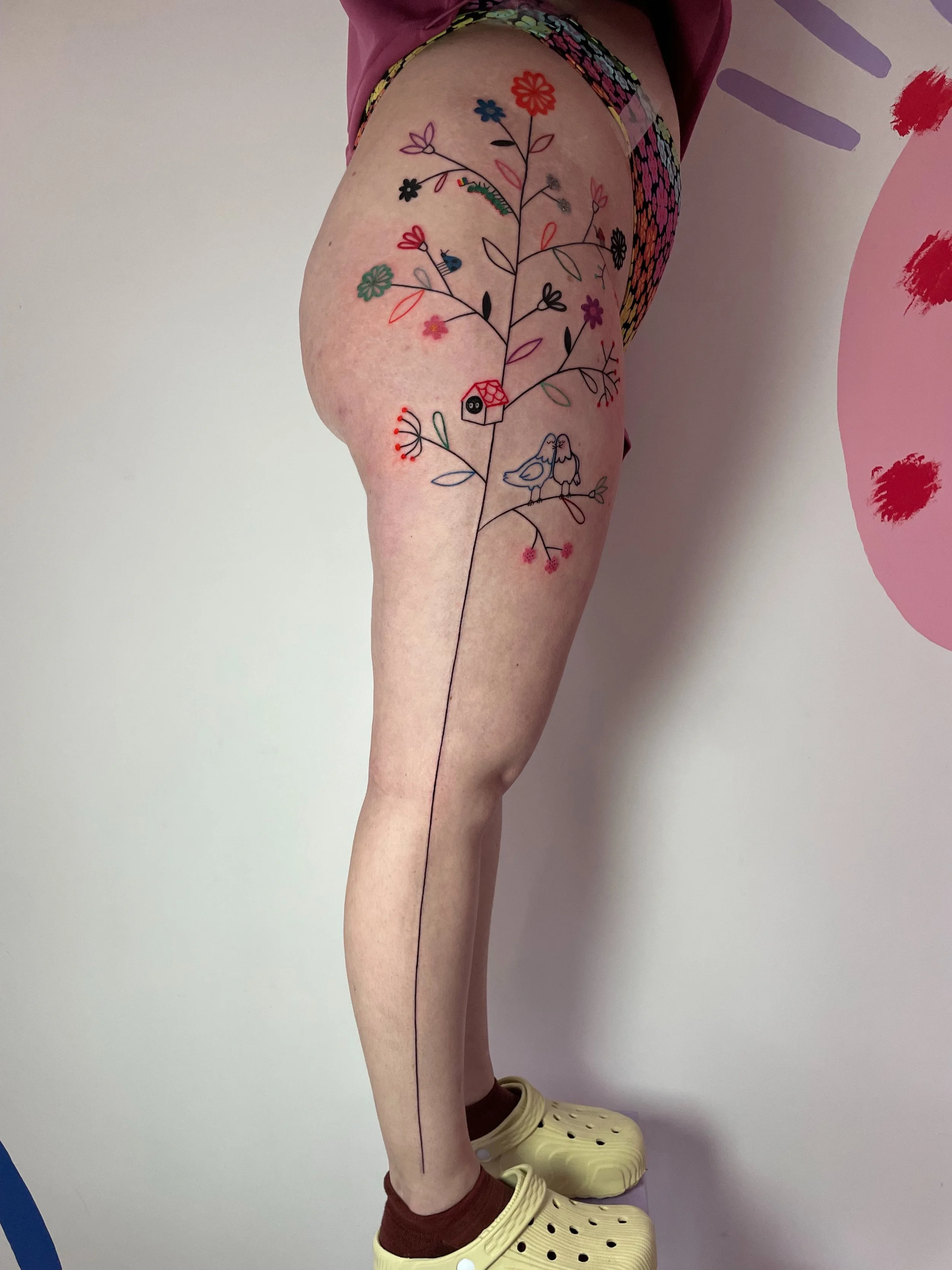 a full leg tattoo - a tree with flowers berries and bugs