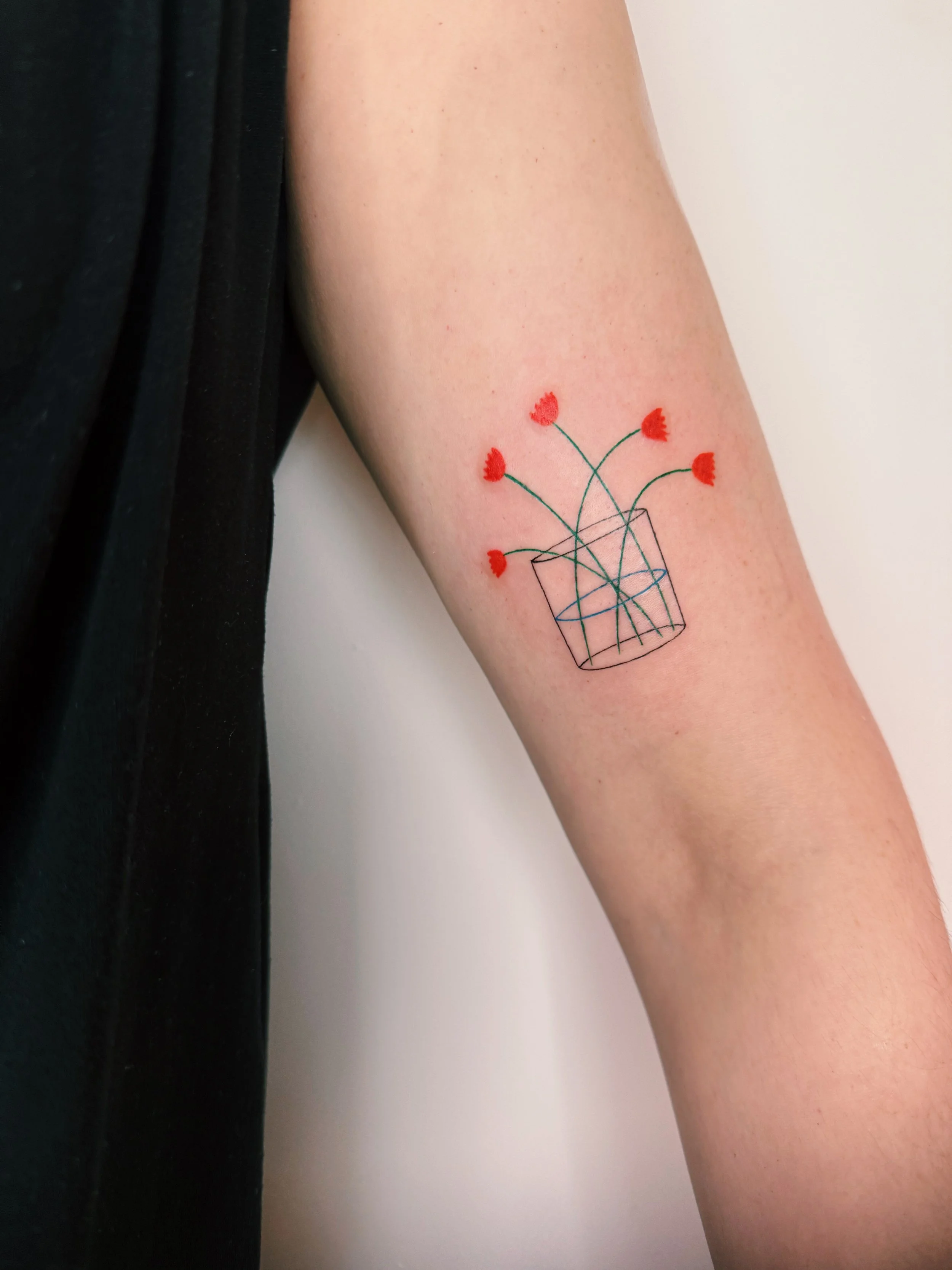 a tattoo of a vase with tulips