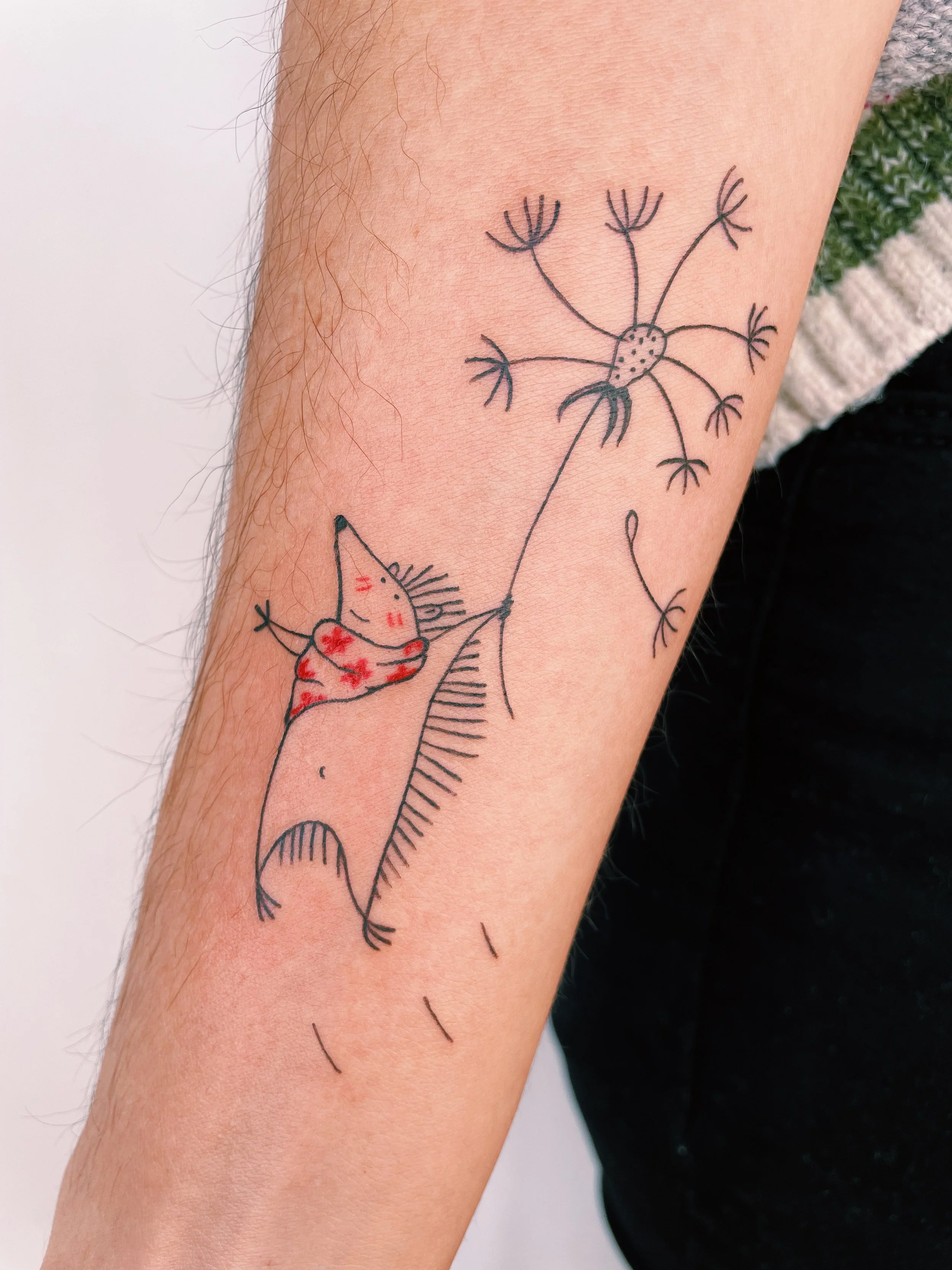 a custom tattoo of a hedgehog flying on a dandelion