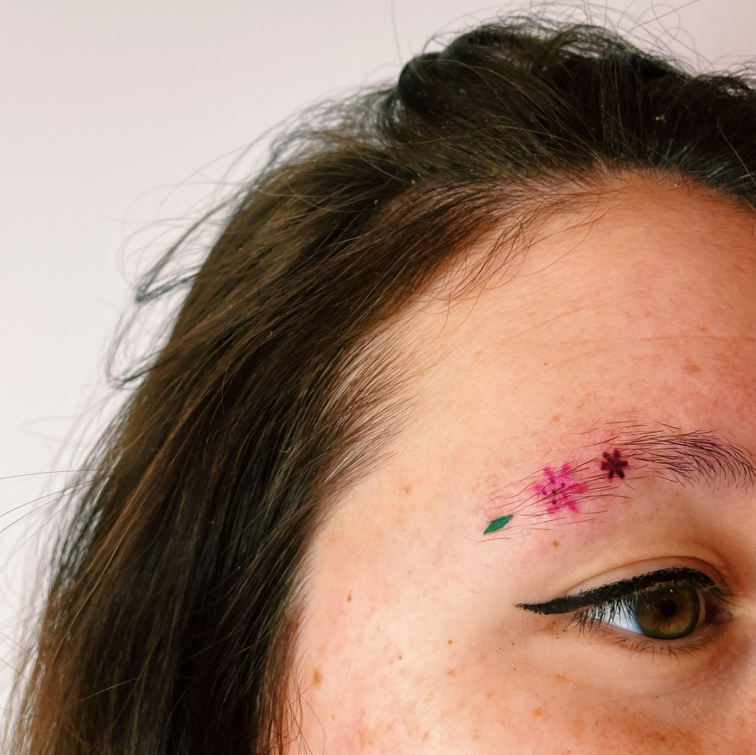 a tattoo of the flowers on an eyebrow