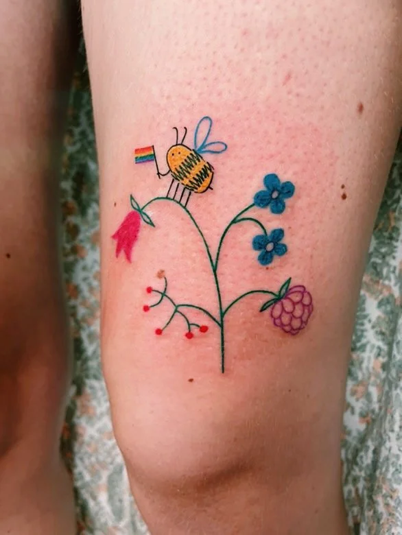 a colorful freehanded tattoo with flowers and berries