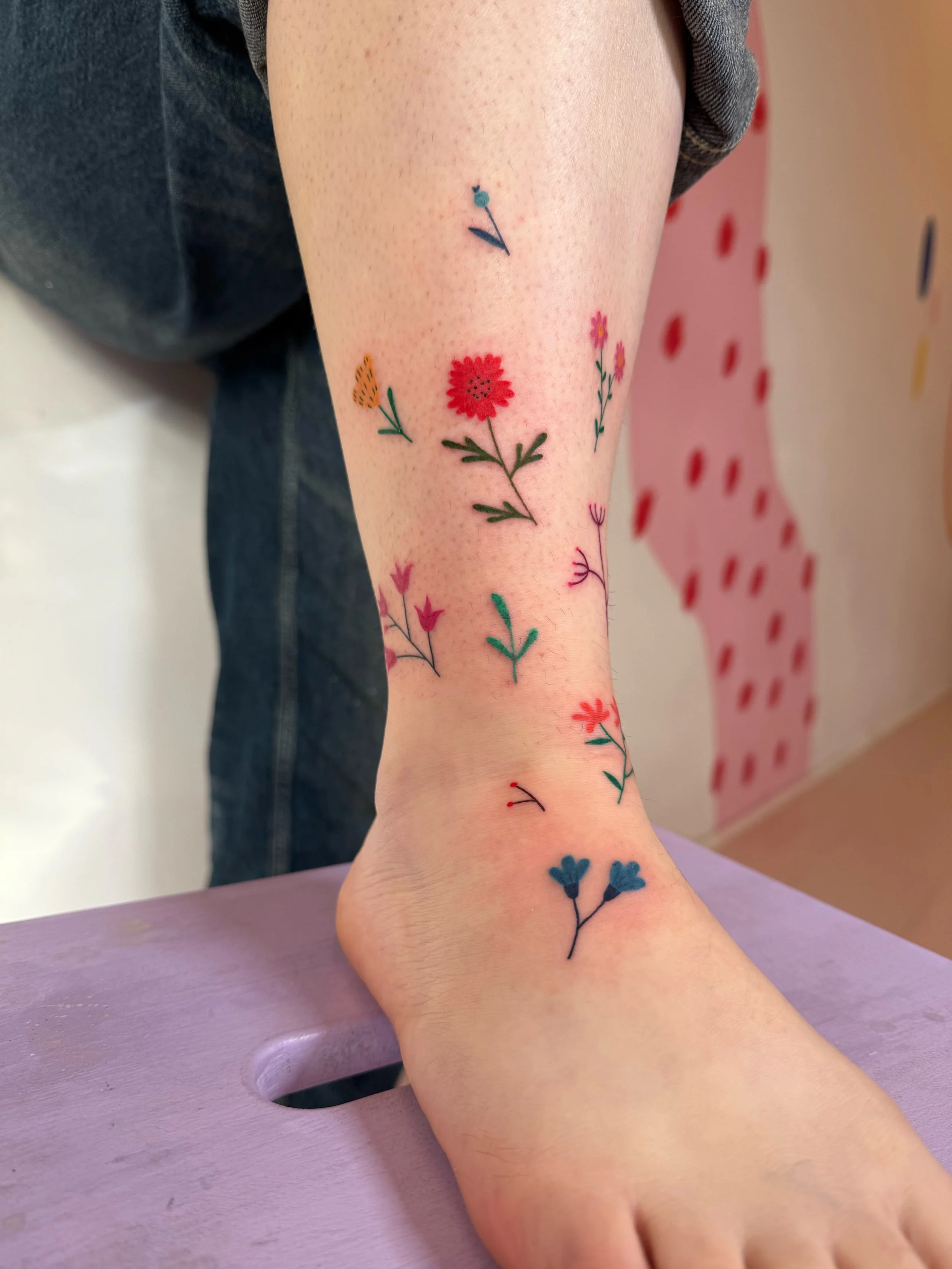A tattoo of colorful flowers on a leg