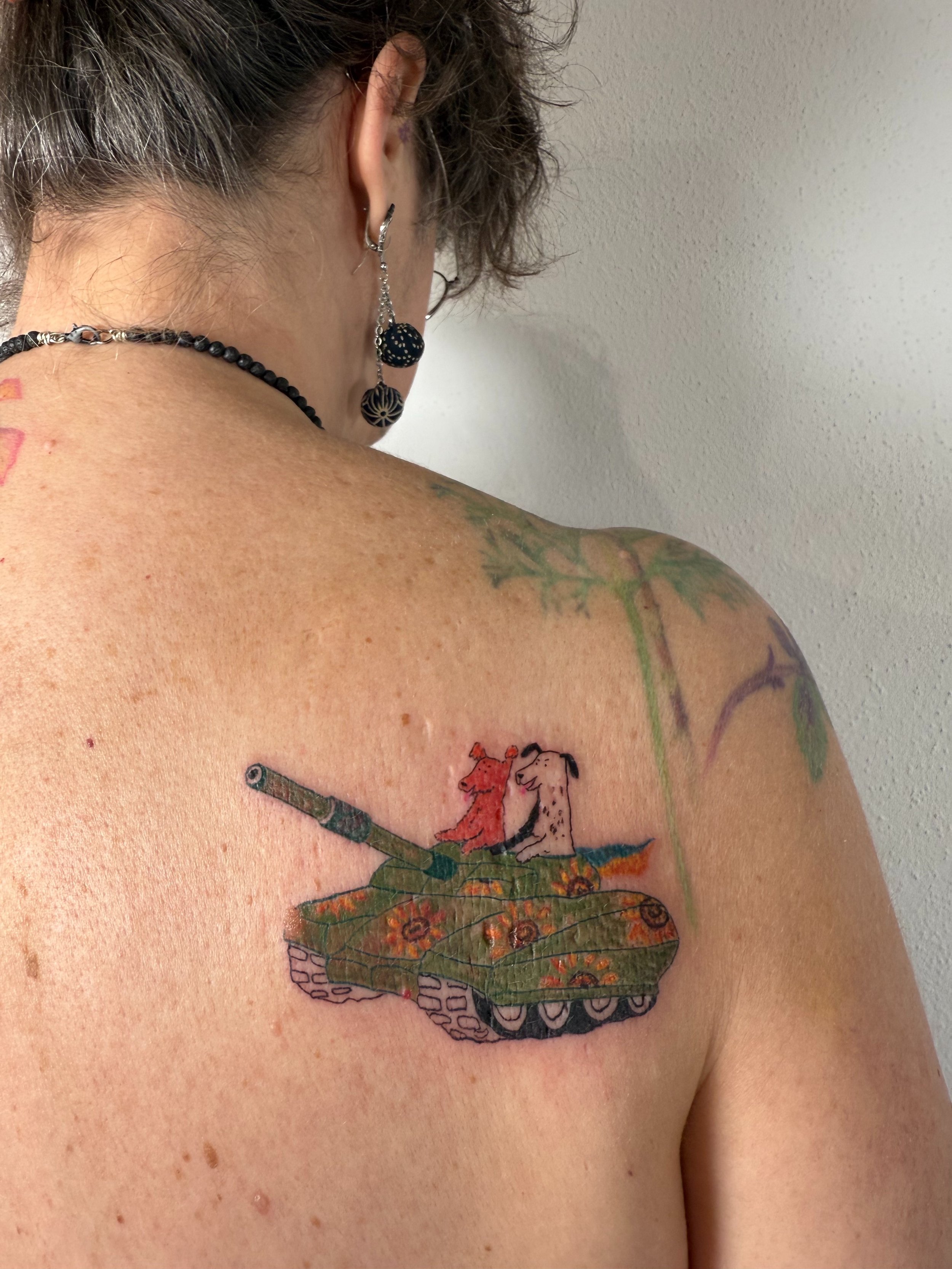 a back tattoo of two dogs in a tank