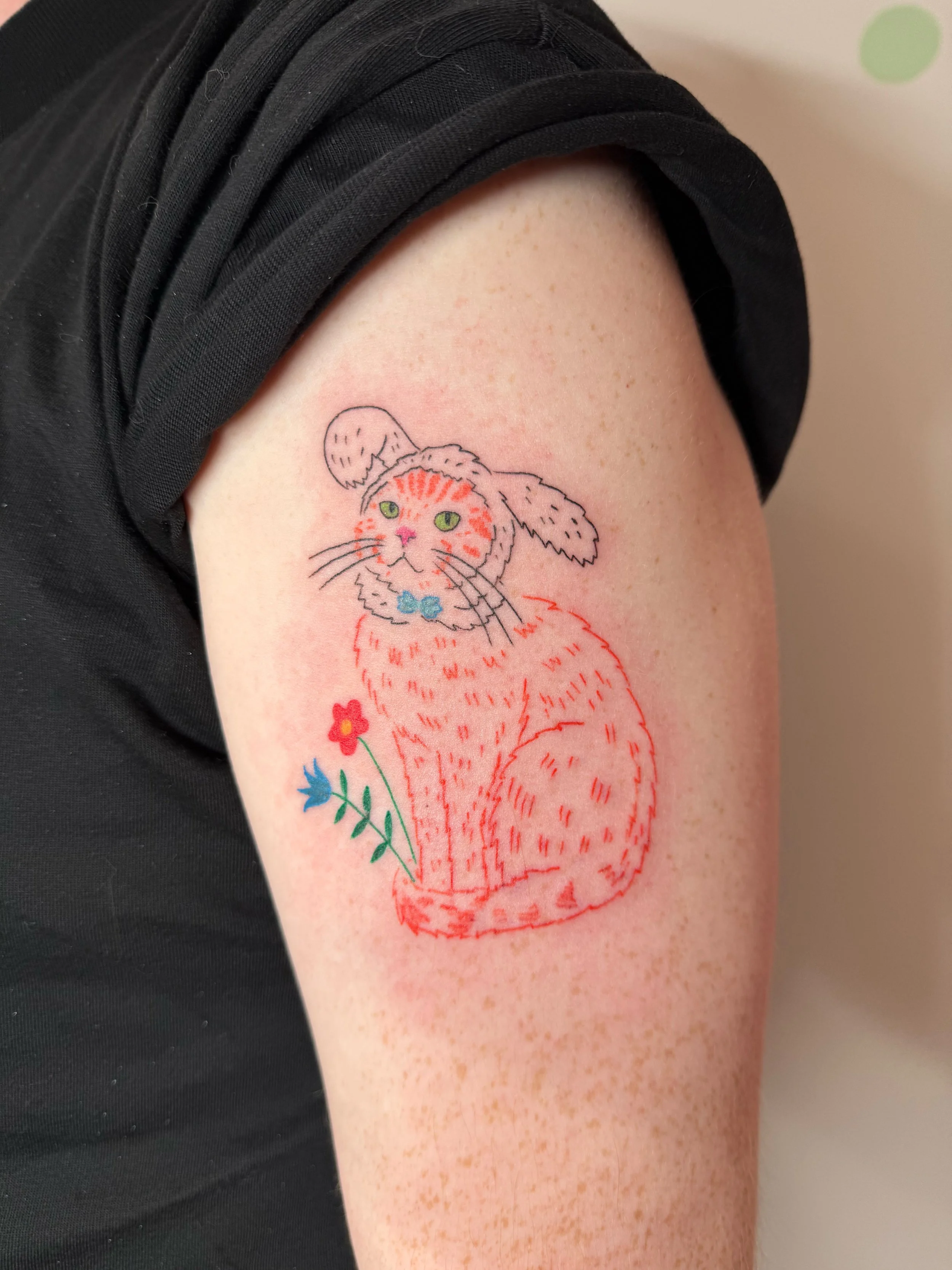 a custom tattoo of an orange cat wearing a bunny costume