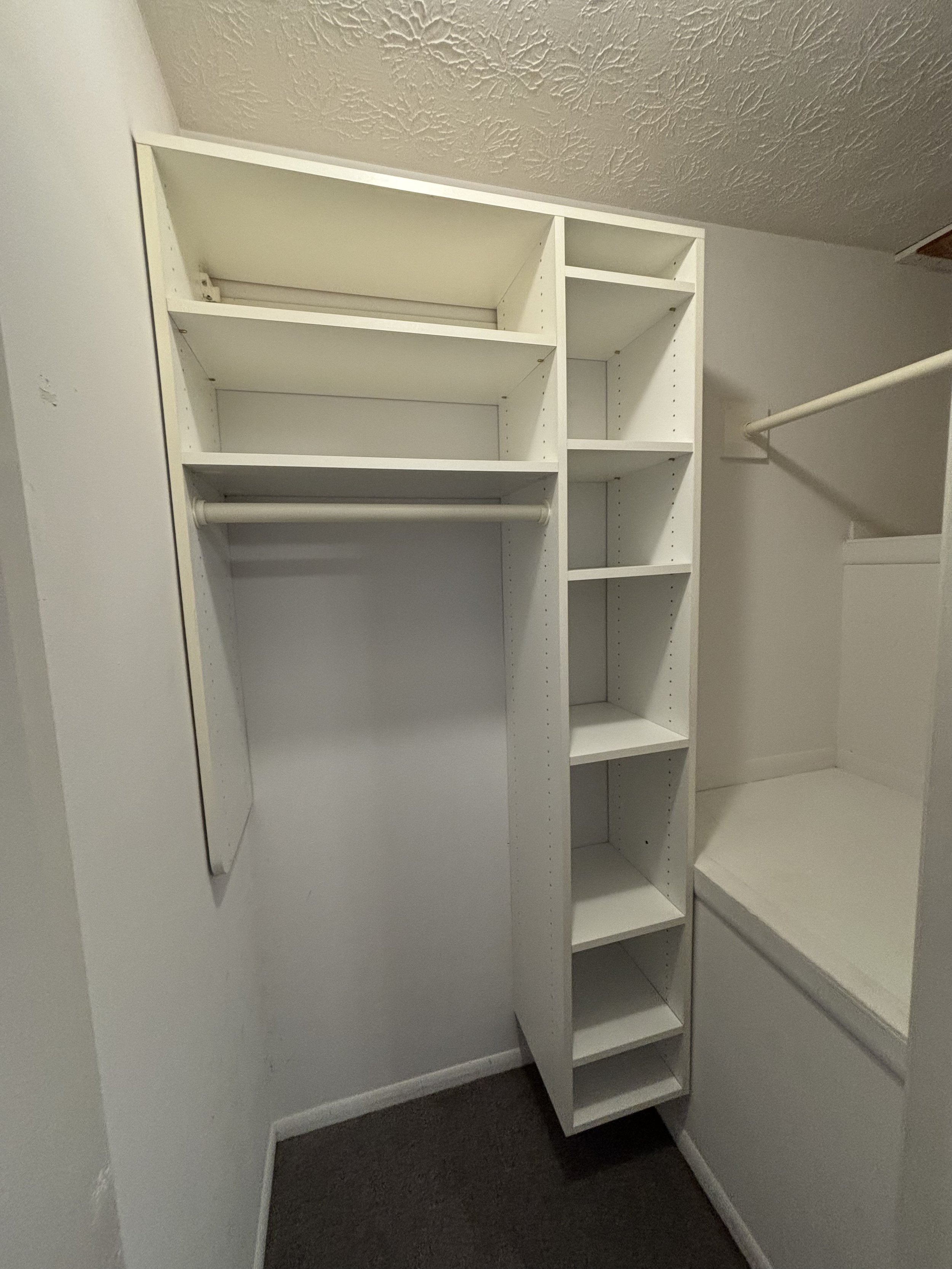 Empty white closet with shelves and hanging rods