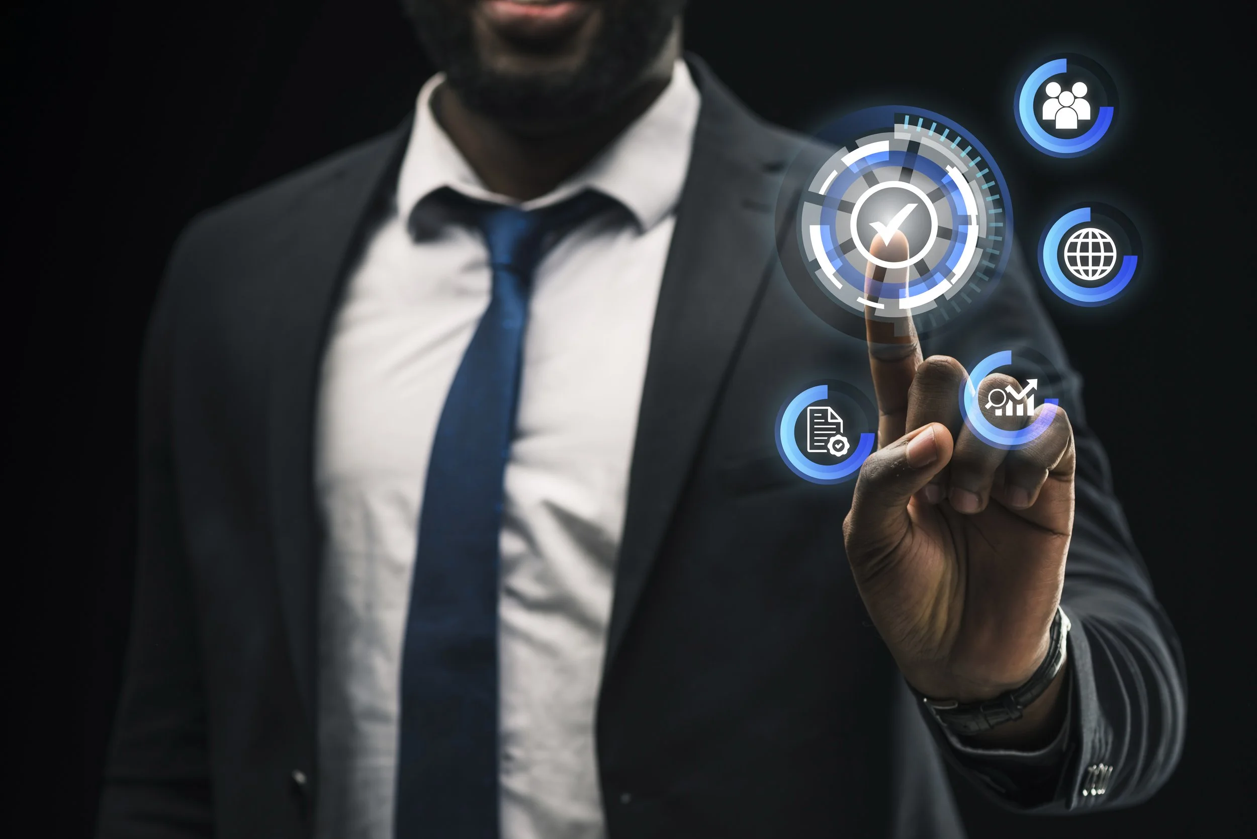 A man in a suit and tie touches a virtual interface with business and technology icons, including a check mark in the center.