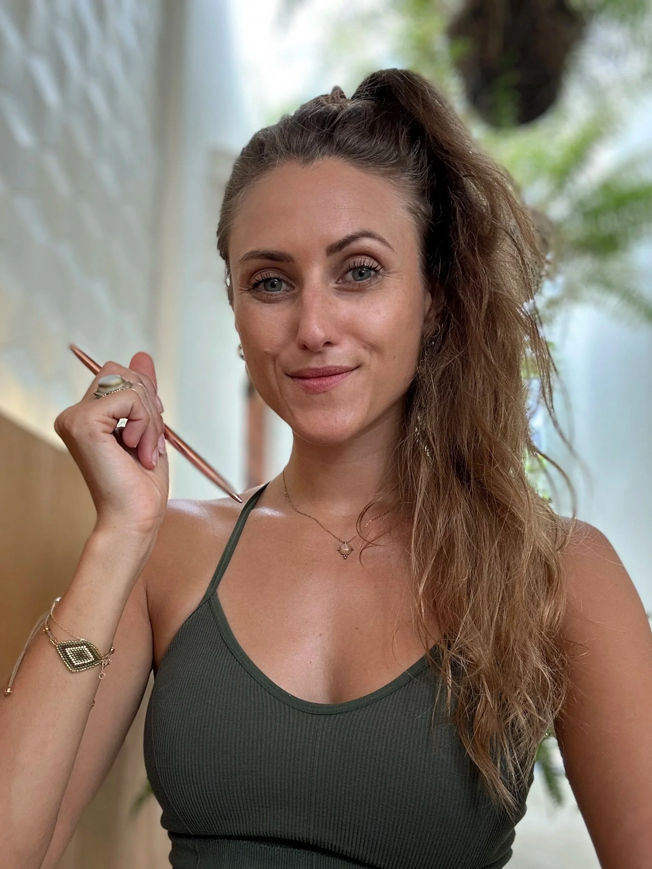 Frau mit Stift in der Hand an einem Schreibtisch.