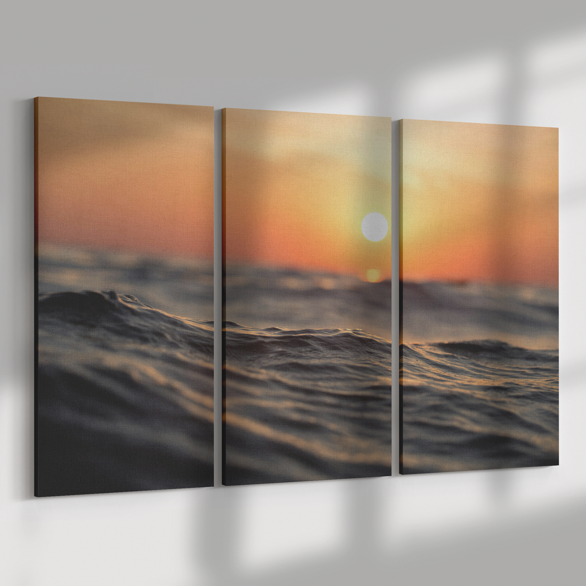 Triptych artwork featuring a sunset over the ocean withIR a red and orange sky, water reflecting the colors, and a distant sun on the horizon.