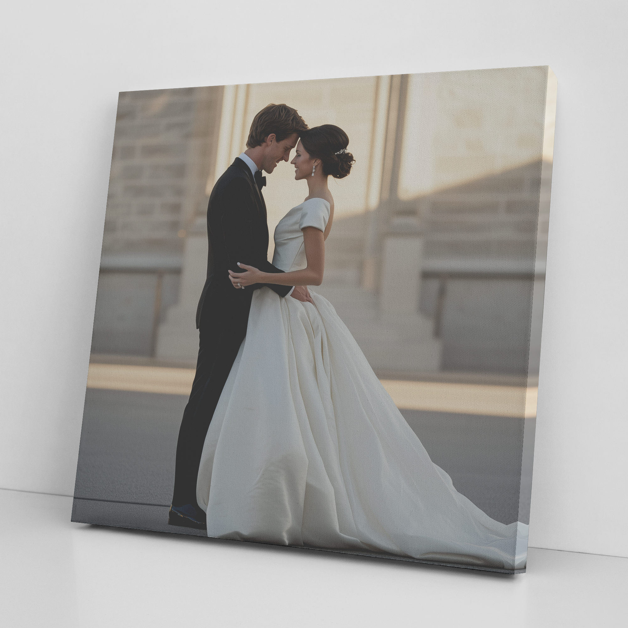 Close-up photograph of a printed photo showing a couple in wedding attire touching foreheads and smiling, with warm backlighting.