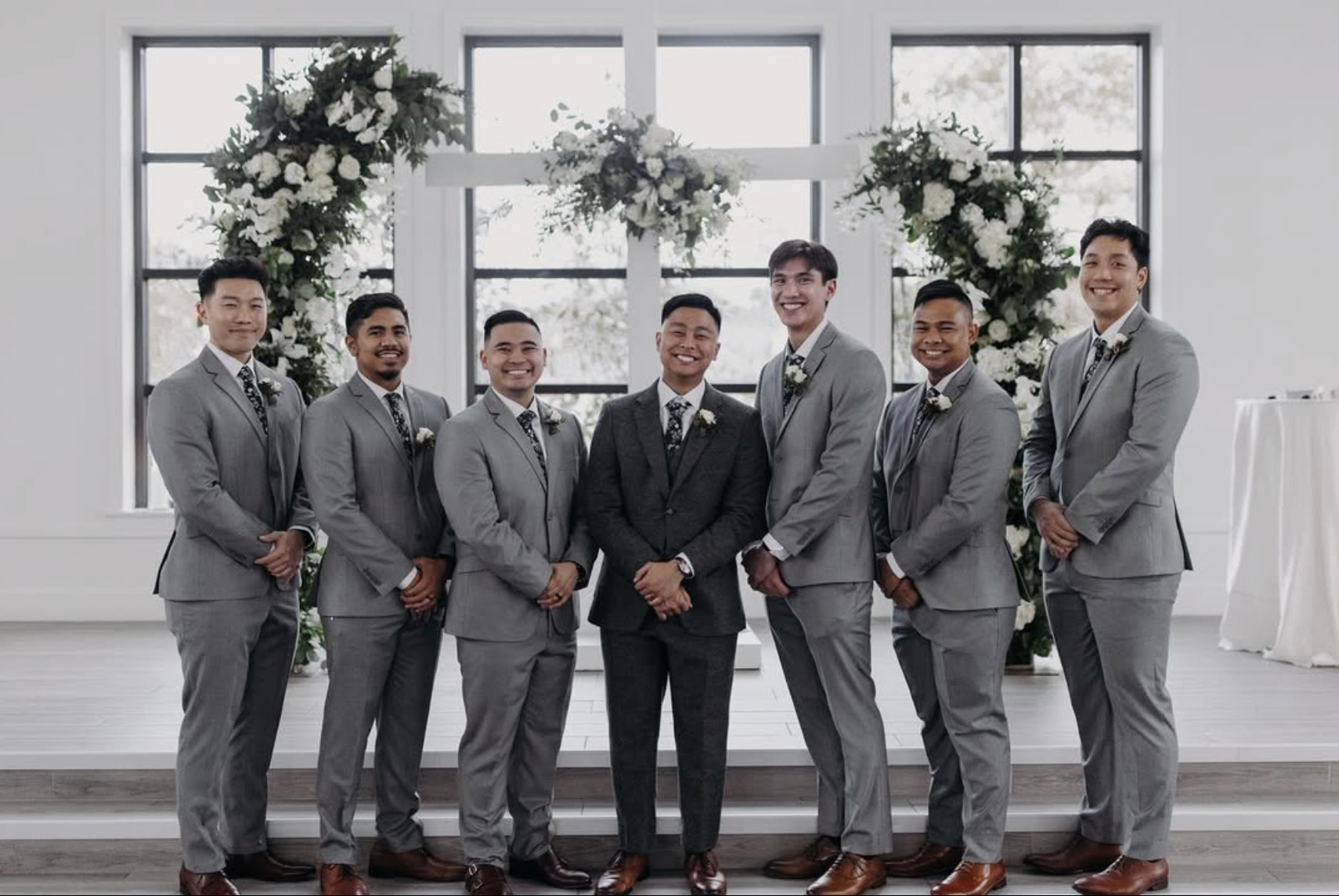 Groom wearing a charcoal suit standing with groomsmen