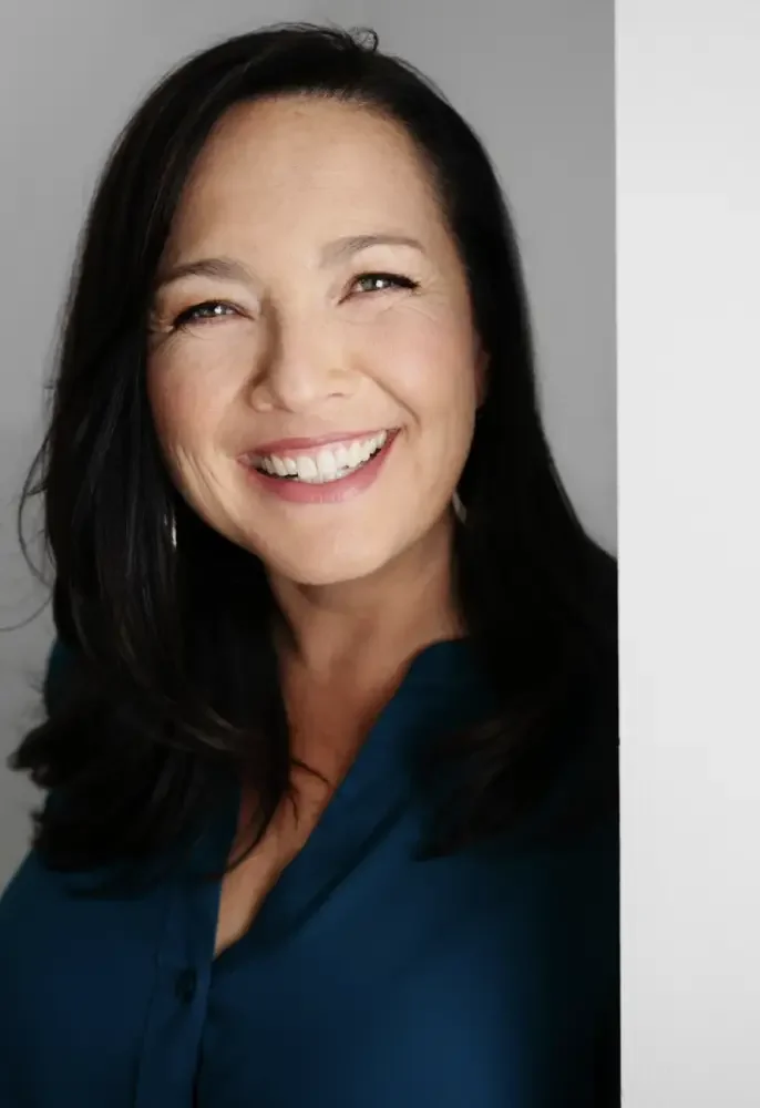 Tatra de la Rosa is a female-presenting person smiling at the camera.