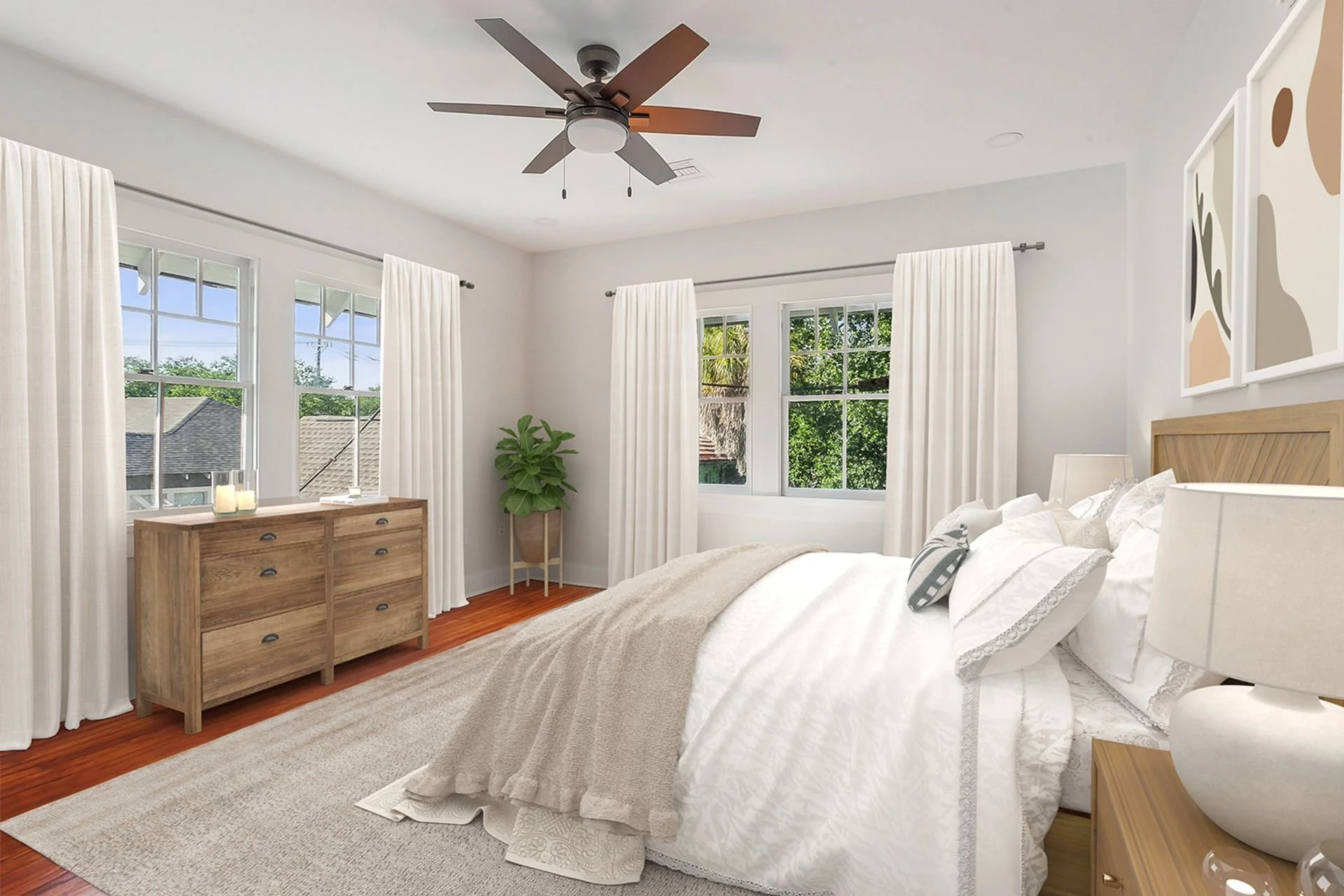 Bright bedroom with white walls, large windows with white curtains, a wooden dresser with decorative candles, a bed with white bedding, patterned pillows, and a beige throw blanket, a white nightstand with a lamp, a potted plant, and a ceiling fan.