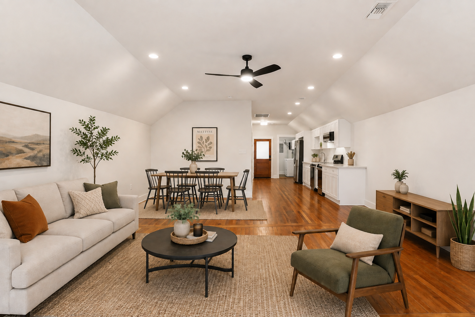 Open-concept living room, dining area, and kitchen with hardwood floors, kitchen features white cabinets and stainless steel appliances. 7 Fontainebleau Drive, 2 bedroom 2 bath for rent New Orleans