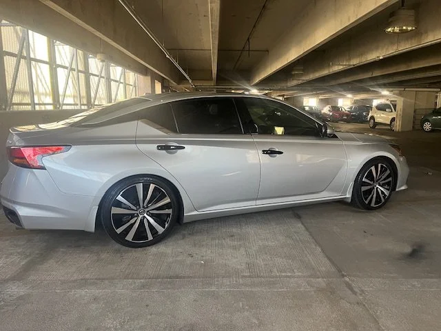 Silver sedan parked in an underground parking garage.