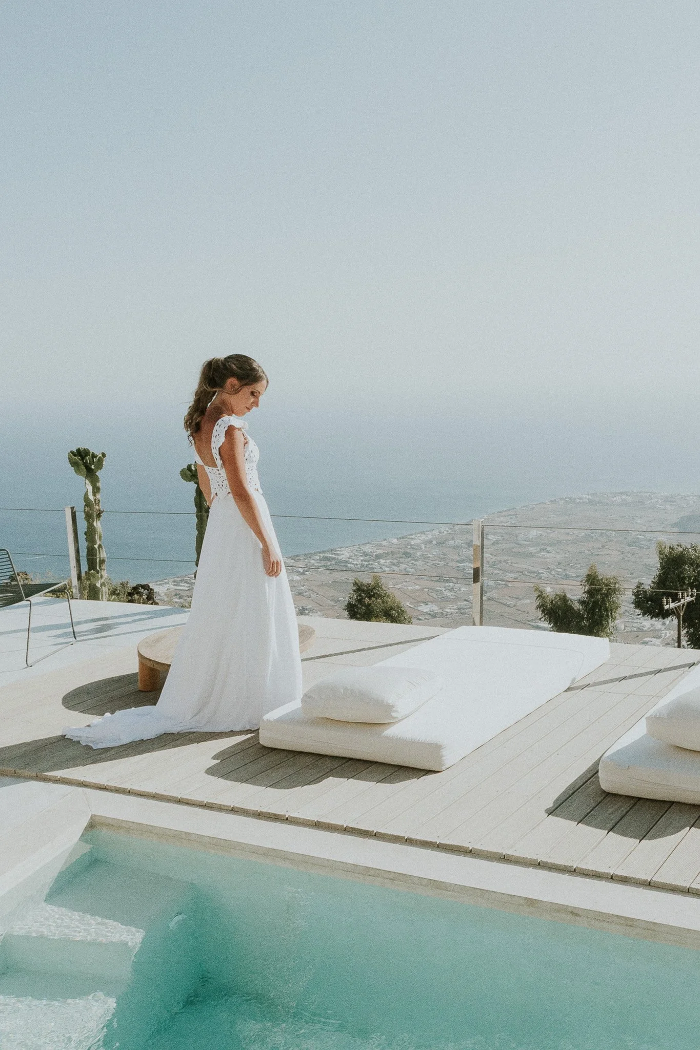 Bride in wedding dress by pool, Santorini - Alexandros Aidonis