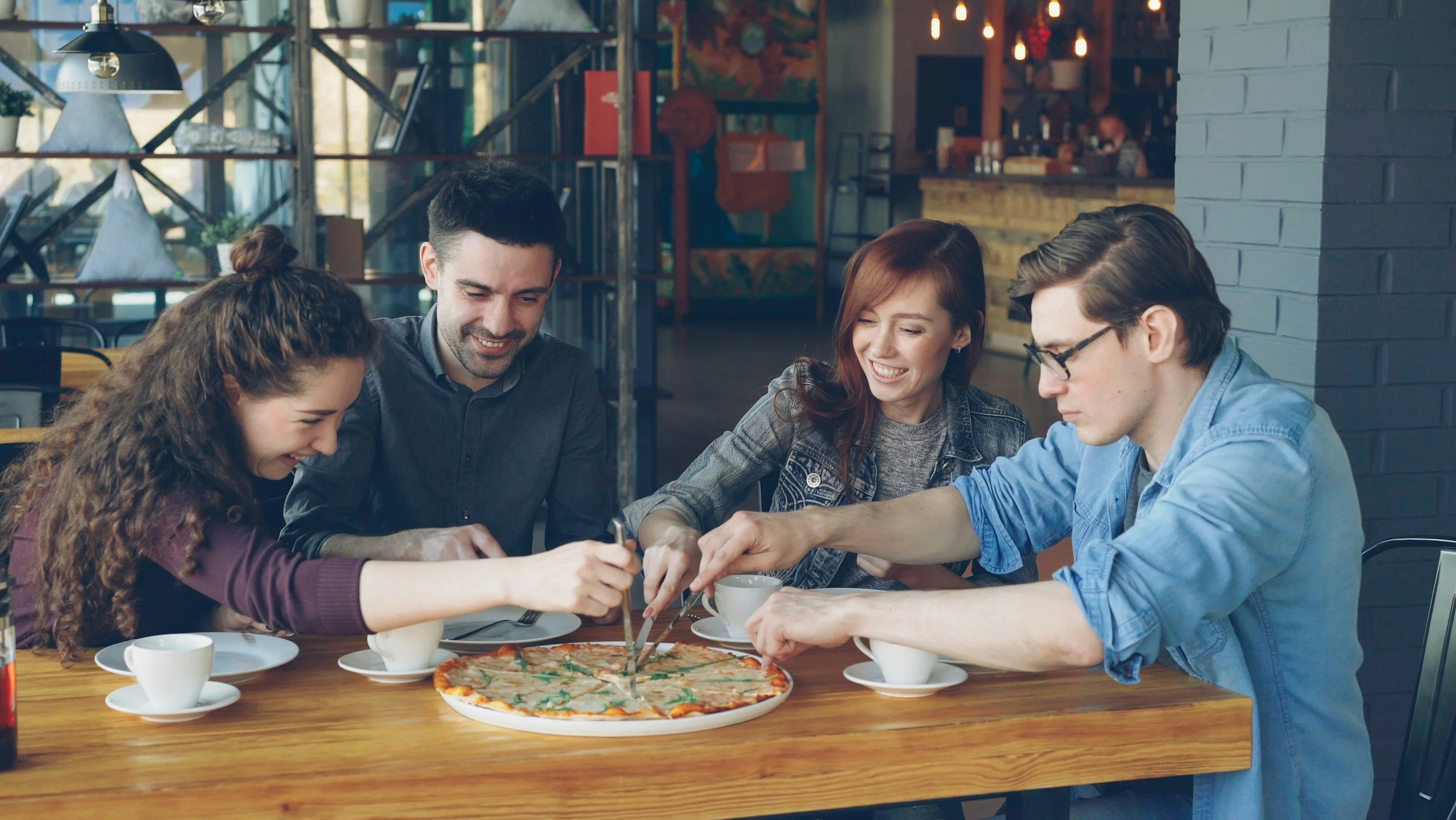 Group of friends enjoying pizza at a pub & grill.