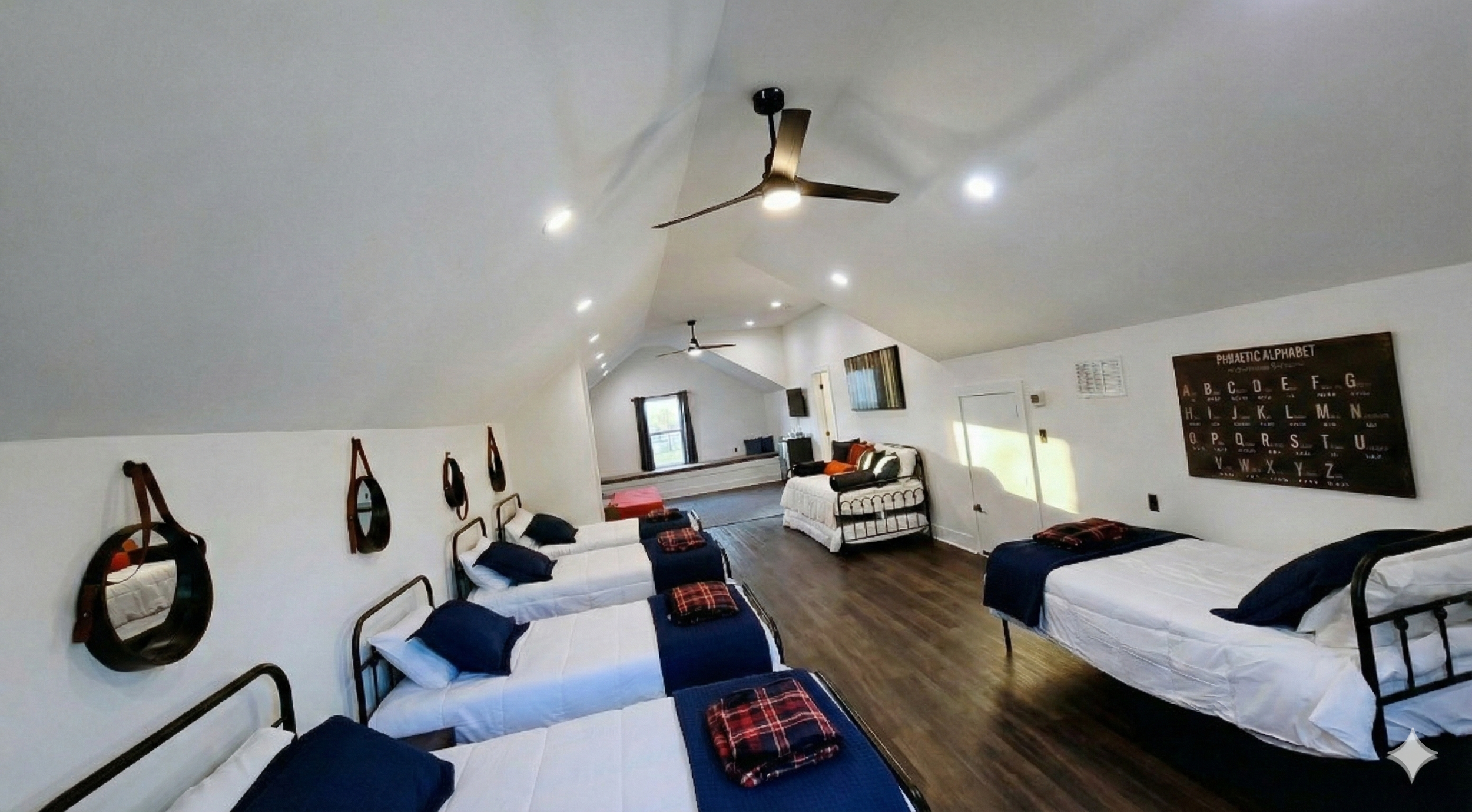 pacious high-capacity bunk room with multiple beds and a dedicated living area inside the 3,500 sq ft main house at Larue Landing near Tyler, TX.