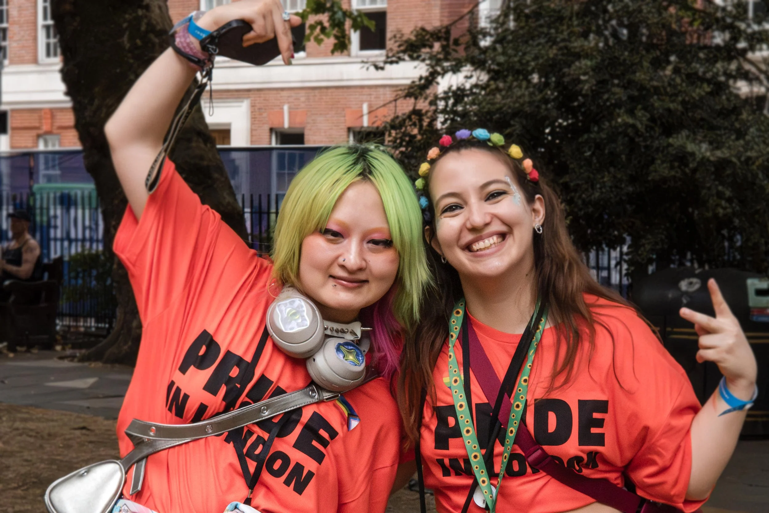 Two Pride in London accessibility stewards, posing within Golden Square