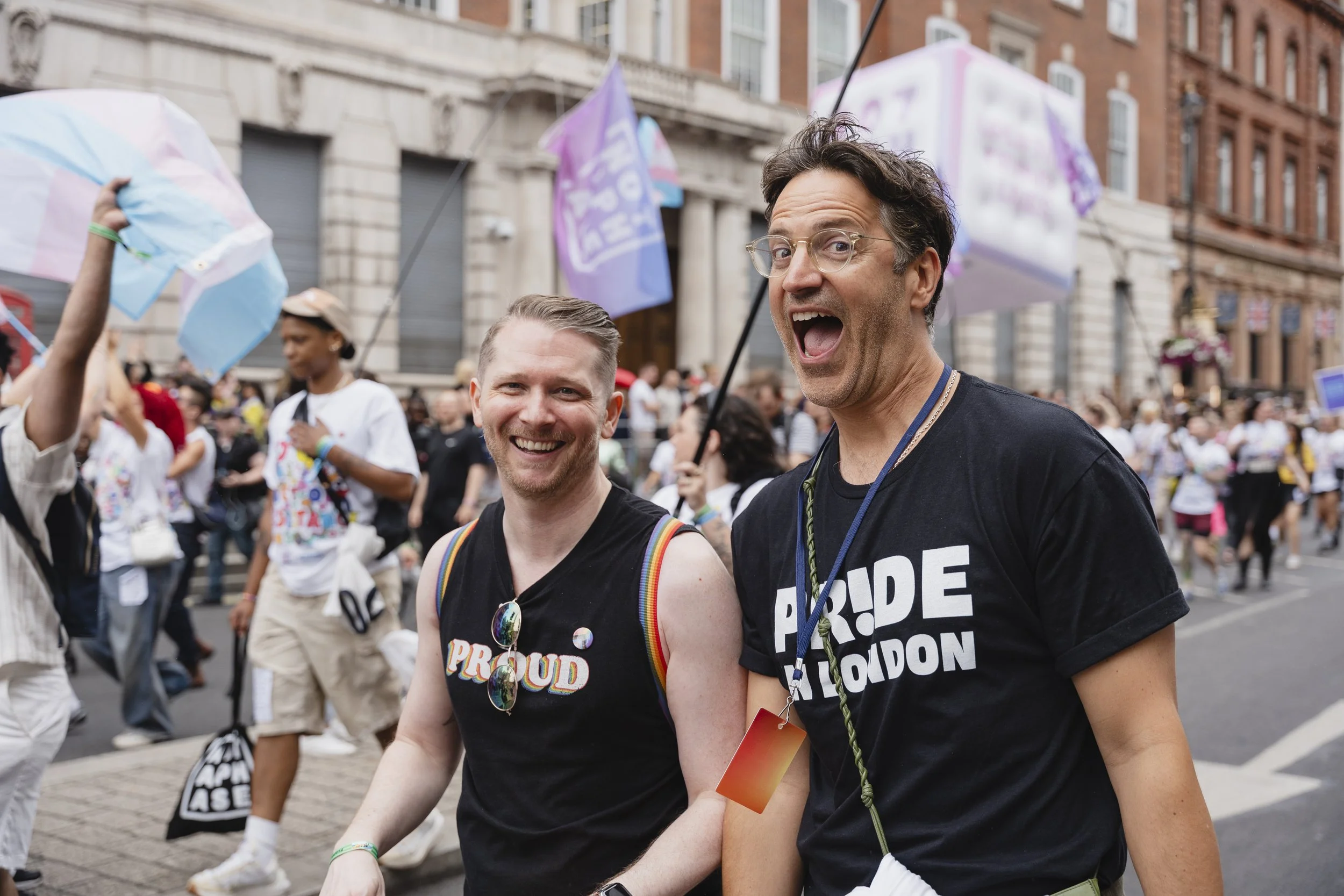 Two Pride in London volunteers marching with the parade