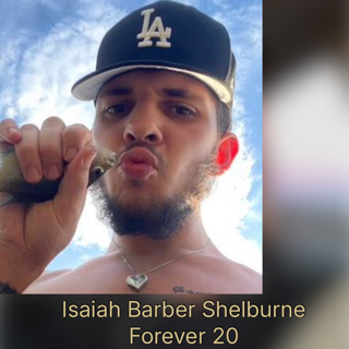 A young man wearing a Los Angeles Dodgers cap making a kissing face outdoors with a blue sky background.
