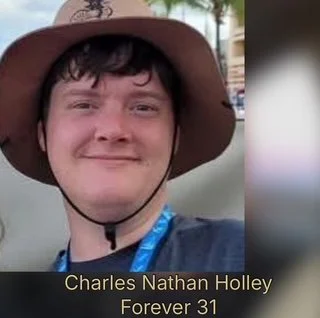 A young man wearing a wide-brimmed hat smiling outdoors, with a caption that reads 'Charles Nathan Holley Forever 31'.