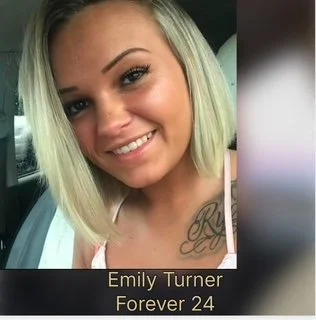 Close-up of a young woman with blonde hair, smiling, with a tattoo on her chest, in a car. Text overlay says 'Emily Turner, Forever 24'.