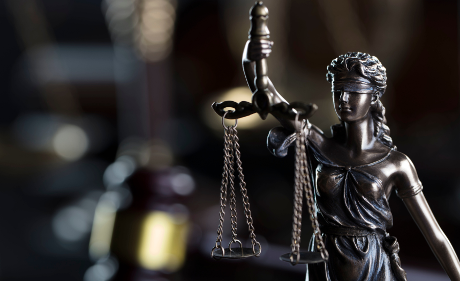 Bronze statue of Lady Justice with a blindfold, holding a scale in her left hand and a sword in her right hand.