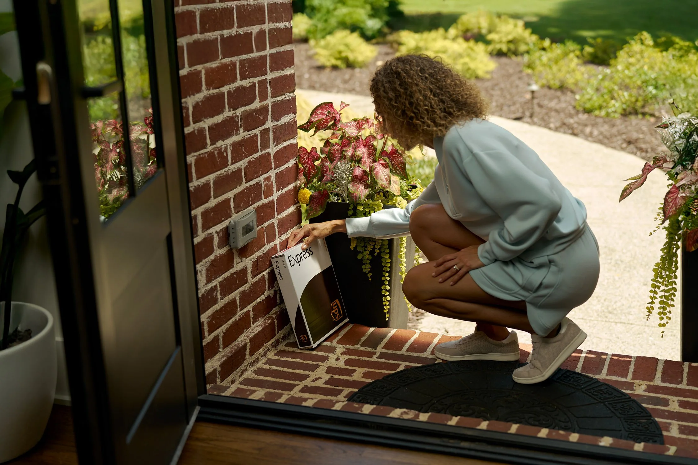 woman outside of door looking at ups express box