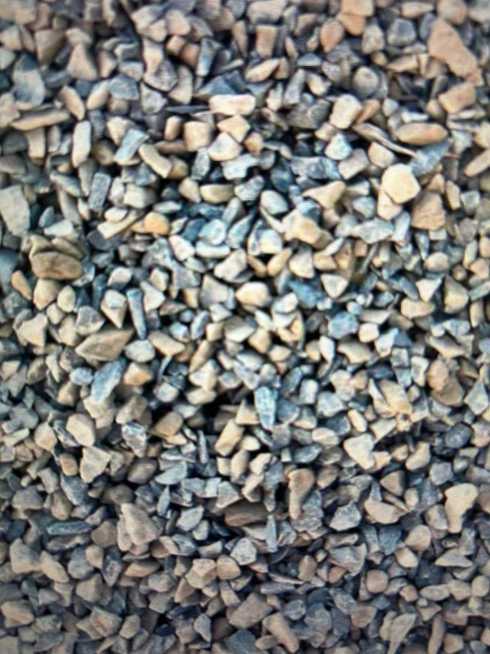 Areia de pedrinhas pequenas em diversas tonalidades.