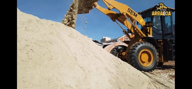 Escavadeira carregando areia em uma construção