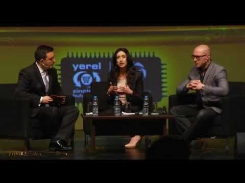 Three people seated on stage in a panel discussion, two men and one woman speaking, with a yellow-green background and a Yereel logo.