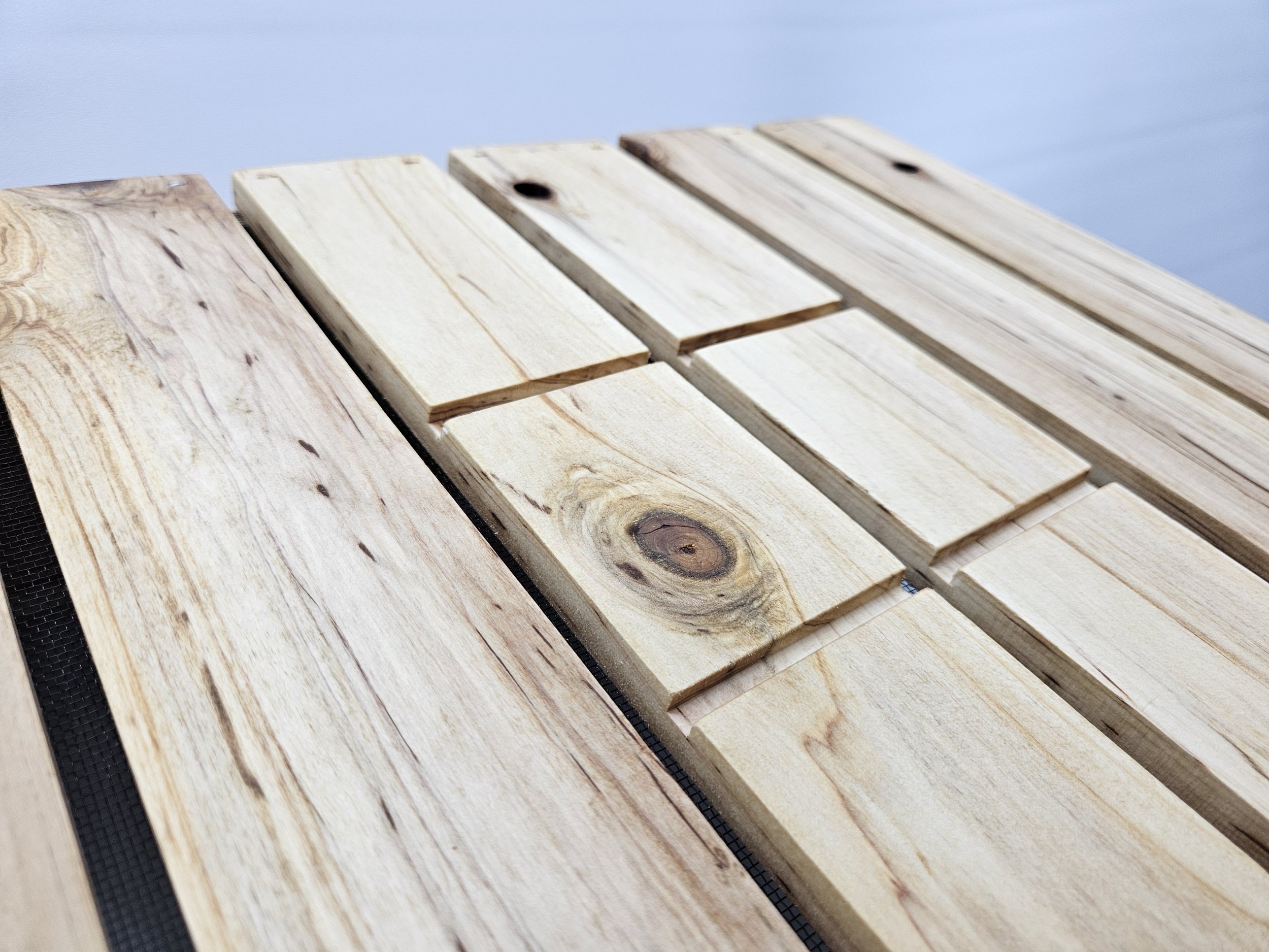 Close-up of cedar bonsai grow box bottom with drainage screen and reinforced wood slats