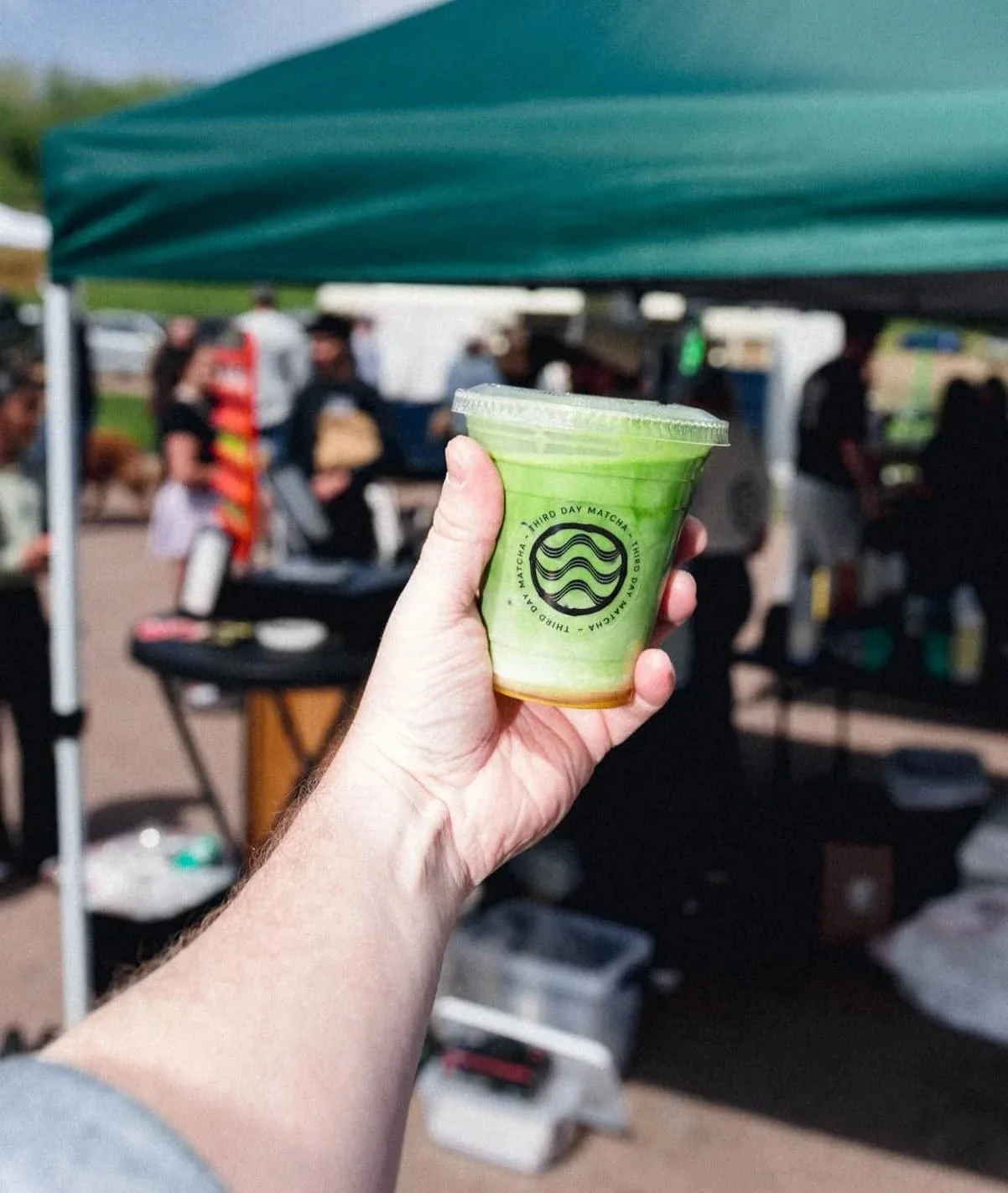 Person holding up cup of iced matcha.