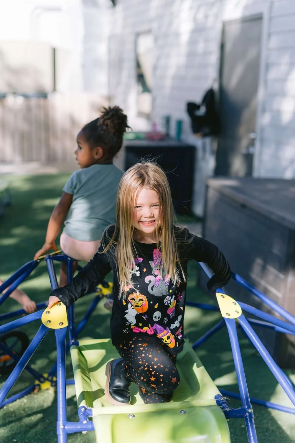 little girl on playground equipment.