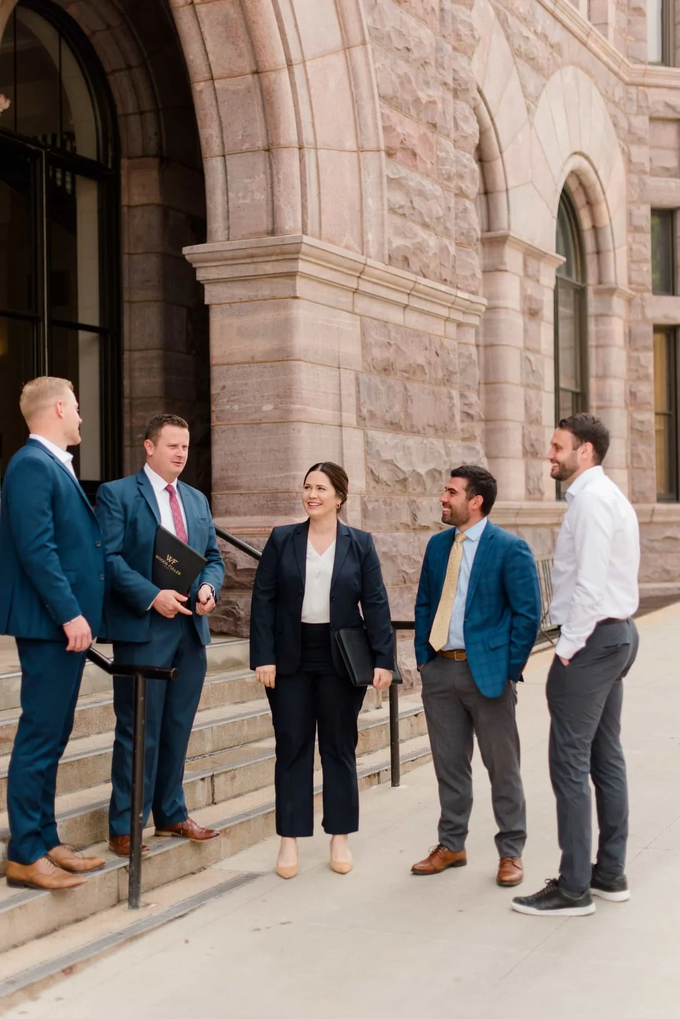 Woods Fuller attorneys talking on steps outside building