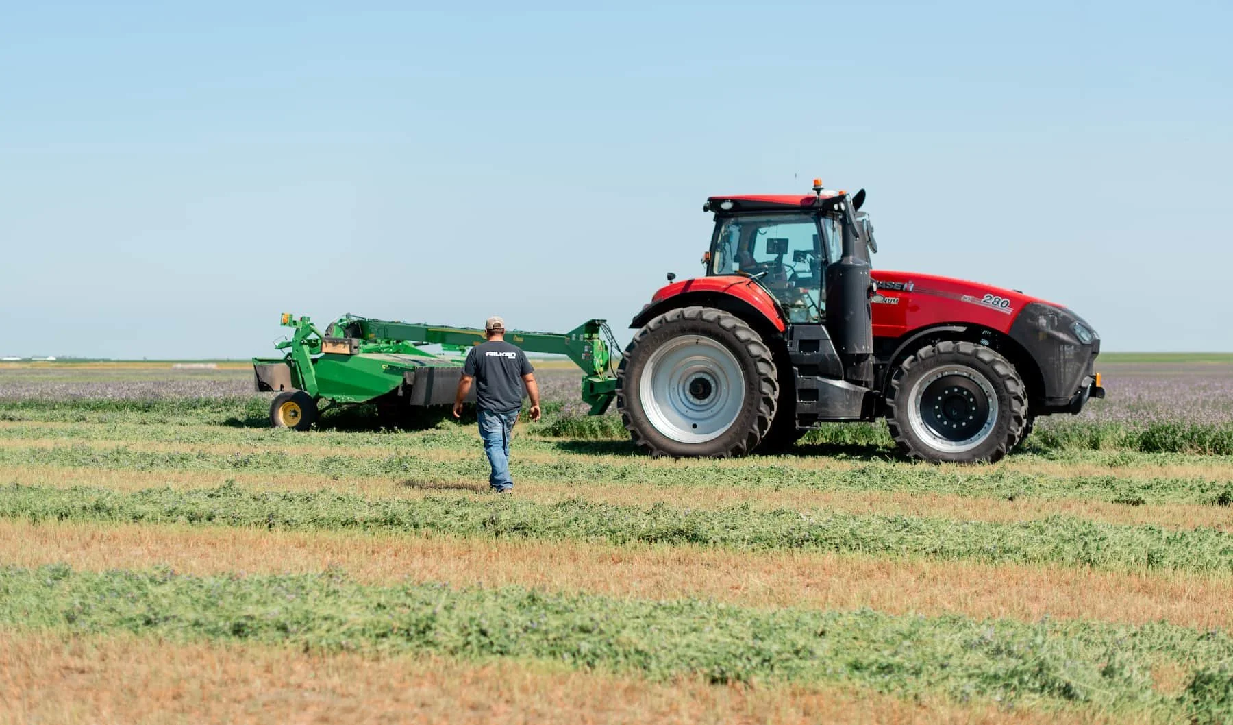 Digital Marketing Photo Asset of John Horter, president of The Rock Block, walking to his tractor and hay cutter with a Rock Block installed.