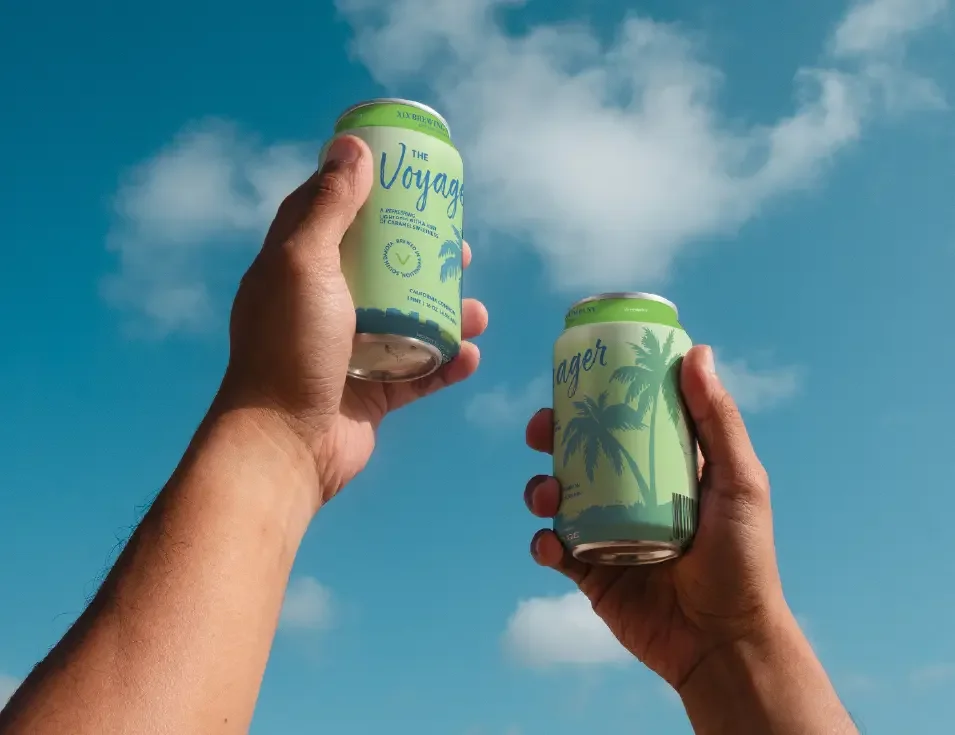 up close image of two hands cheers-ing cans of Voyager Beer